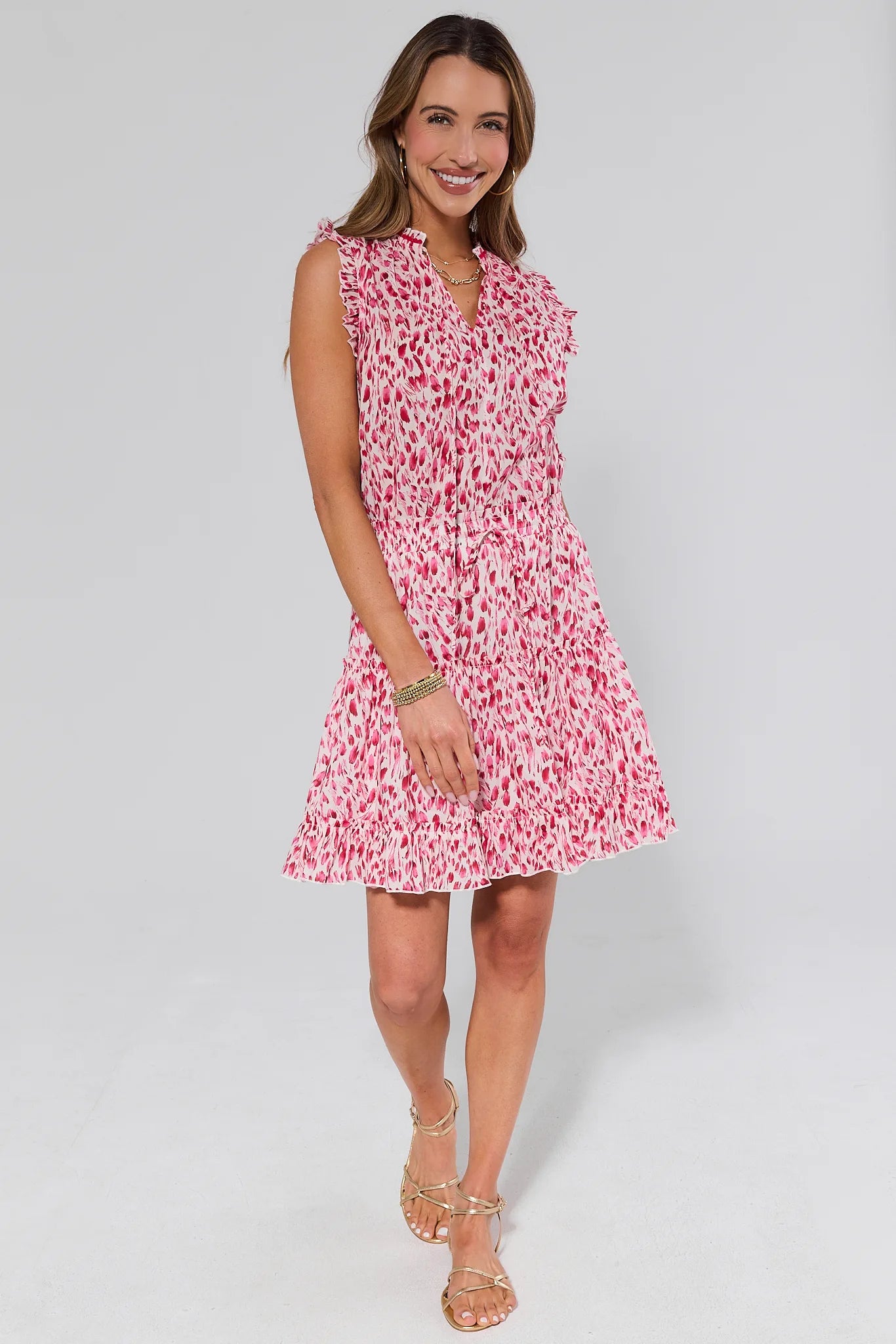 Woman wearing a pink floral dress and sandals on a white background