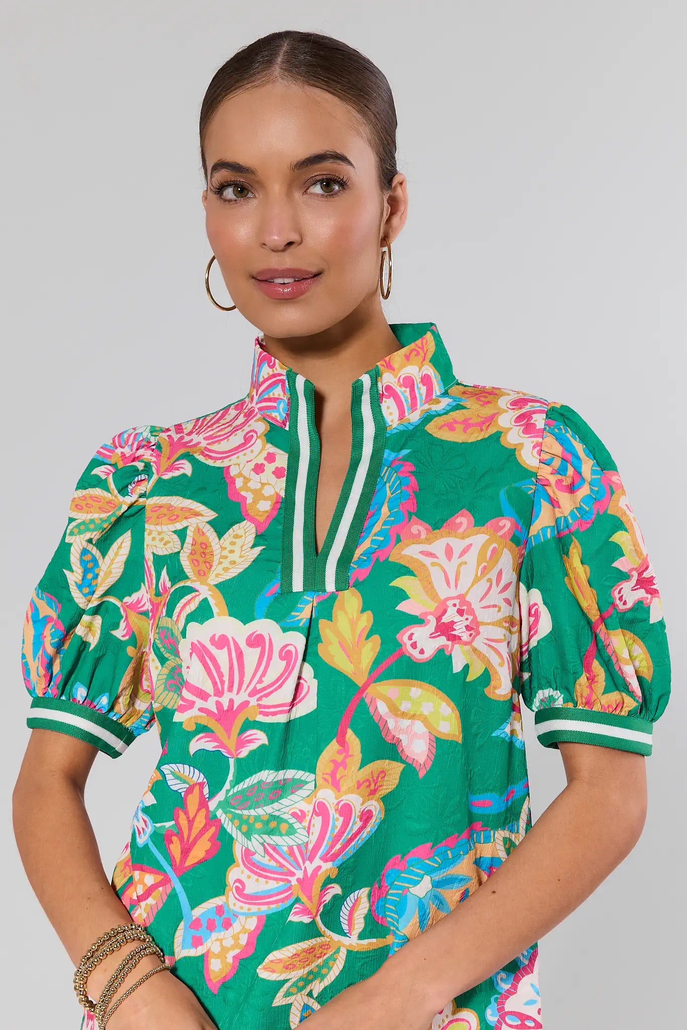 close up Woman wearing a colorful floral blouse with a plain background