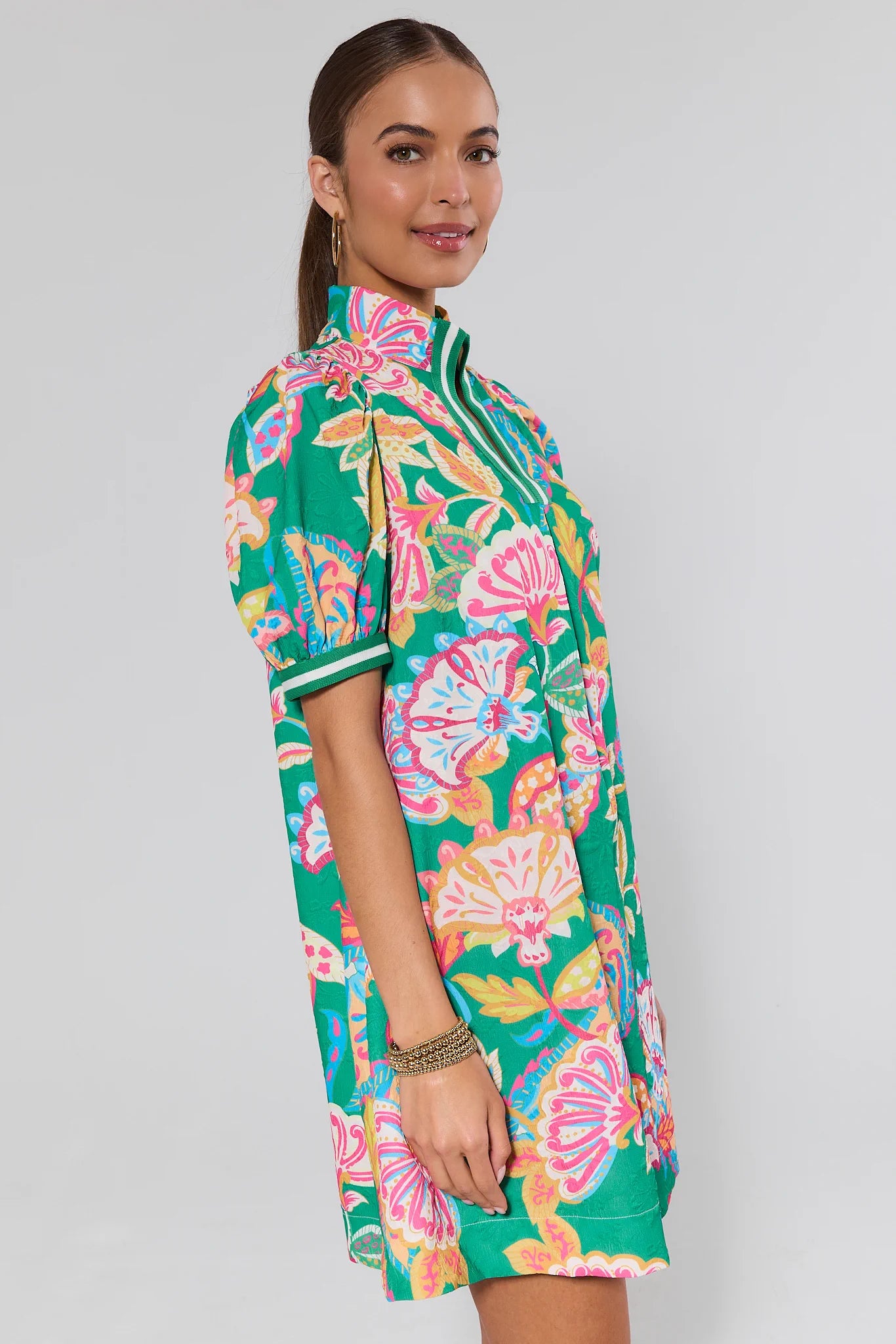 Woman wearing a colorful floral dress on a light background