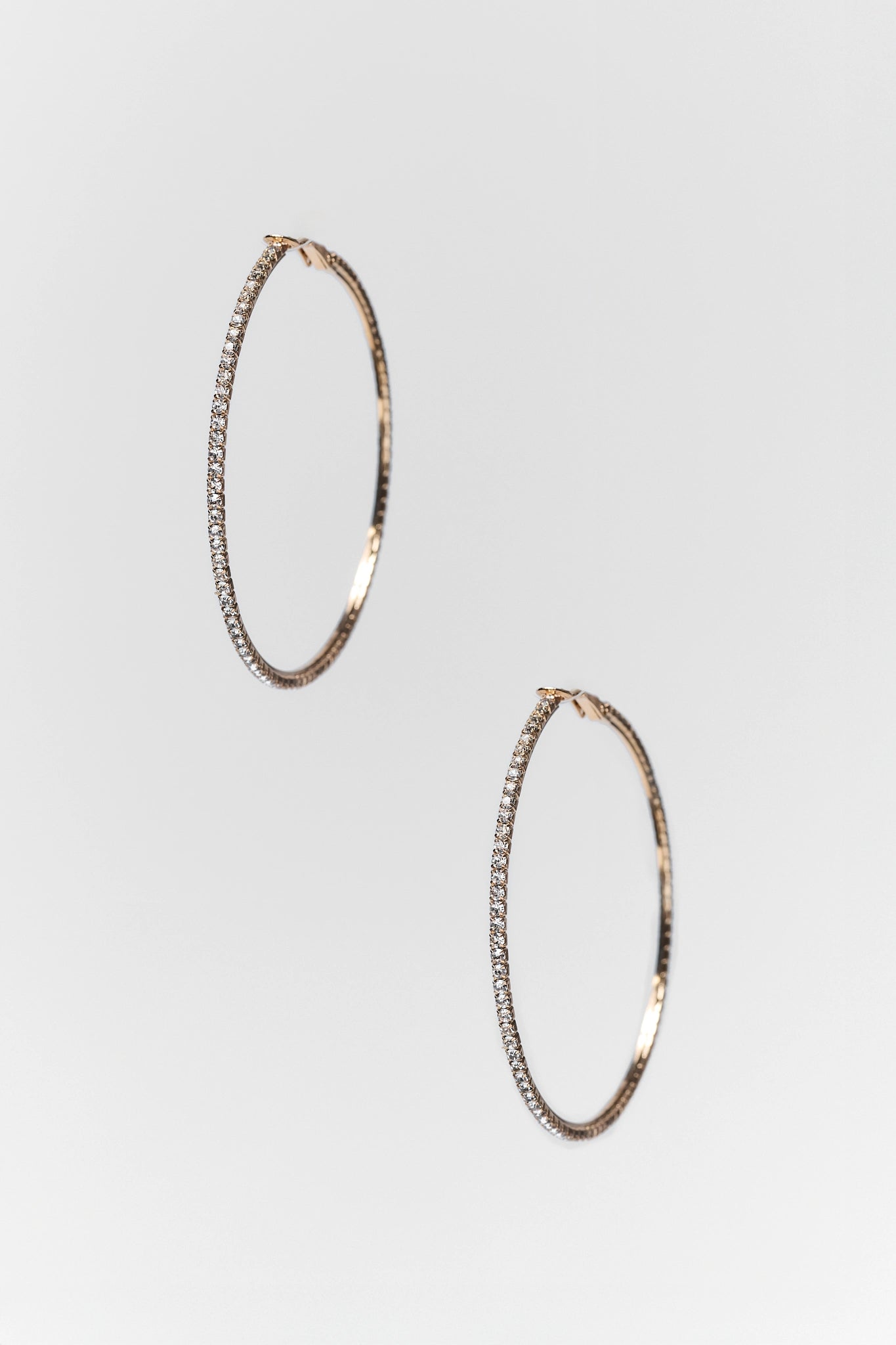 gold rhinestone hoop earrings on white background