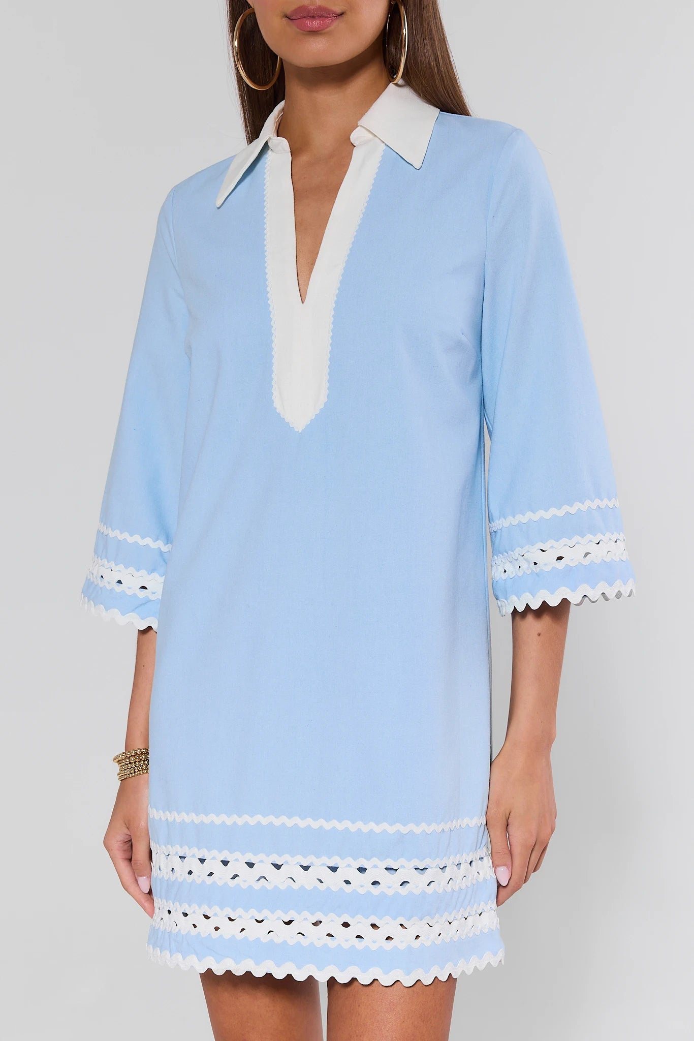 Light blue dress with white trim on a plain background