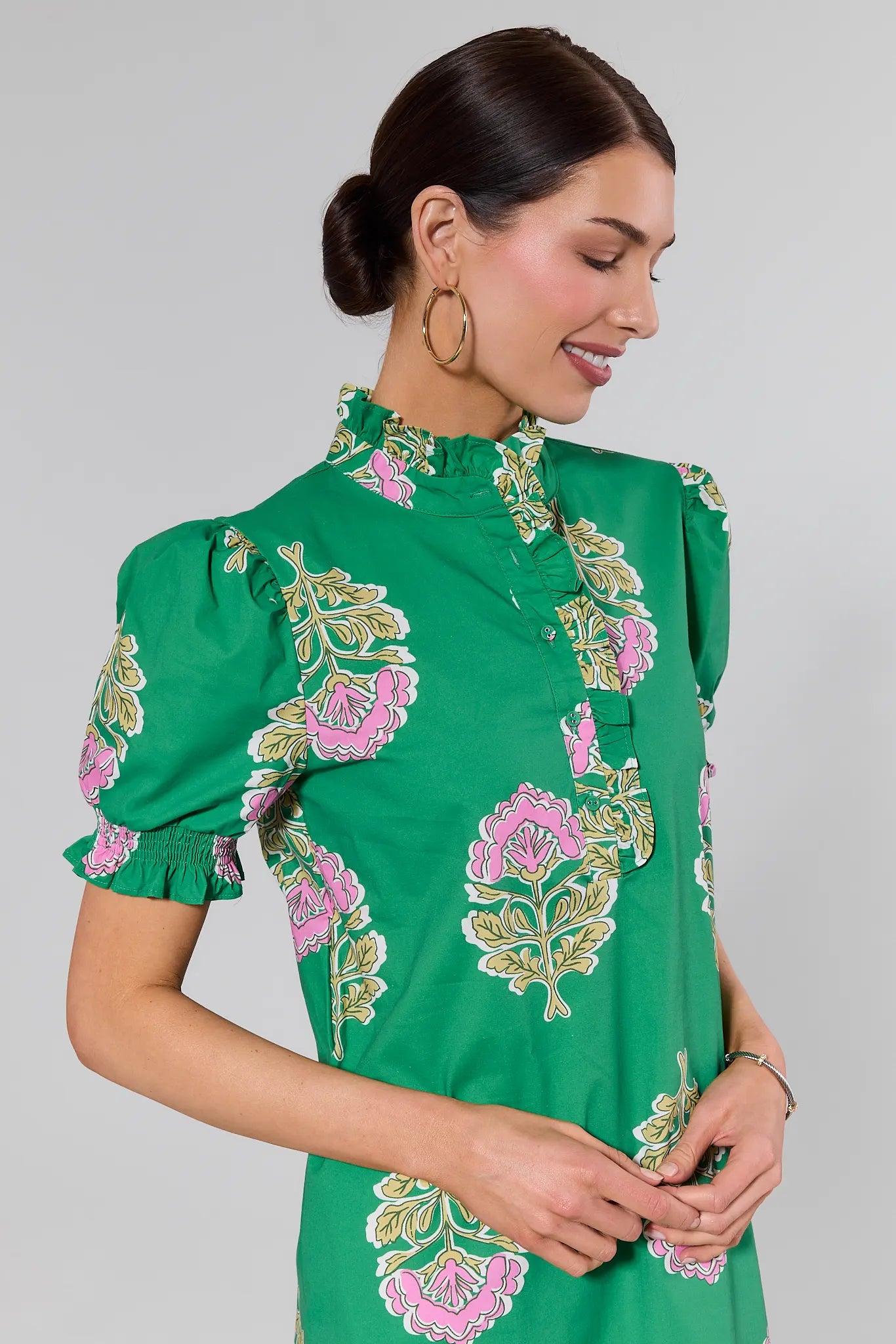 close up Woman wearing a green dress with floral patterns on a gray background