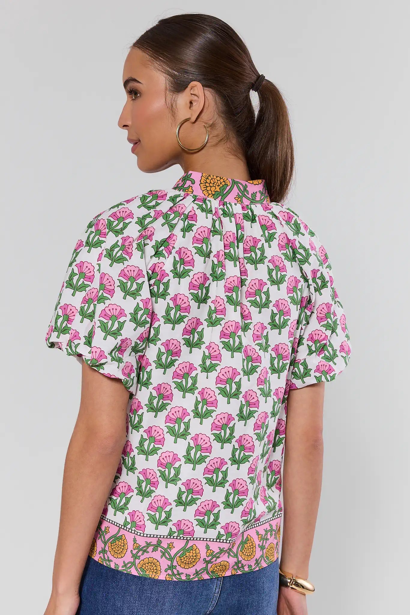 Woman wearing a floral patterned shirt on a plain background