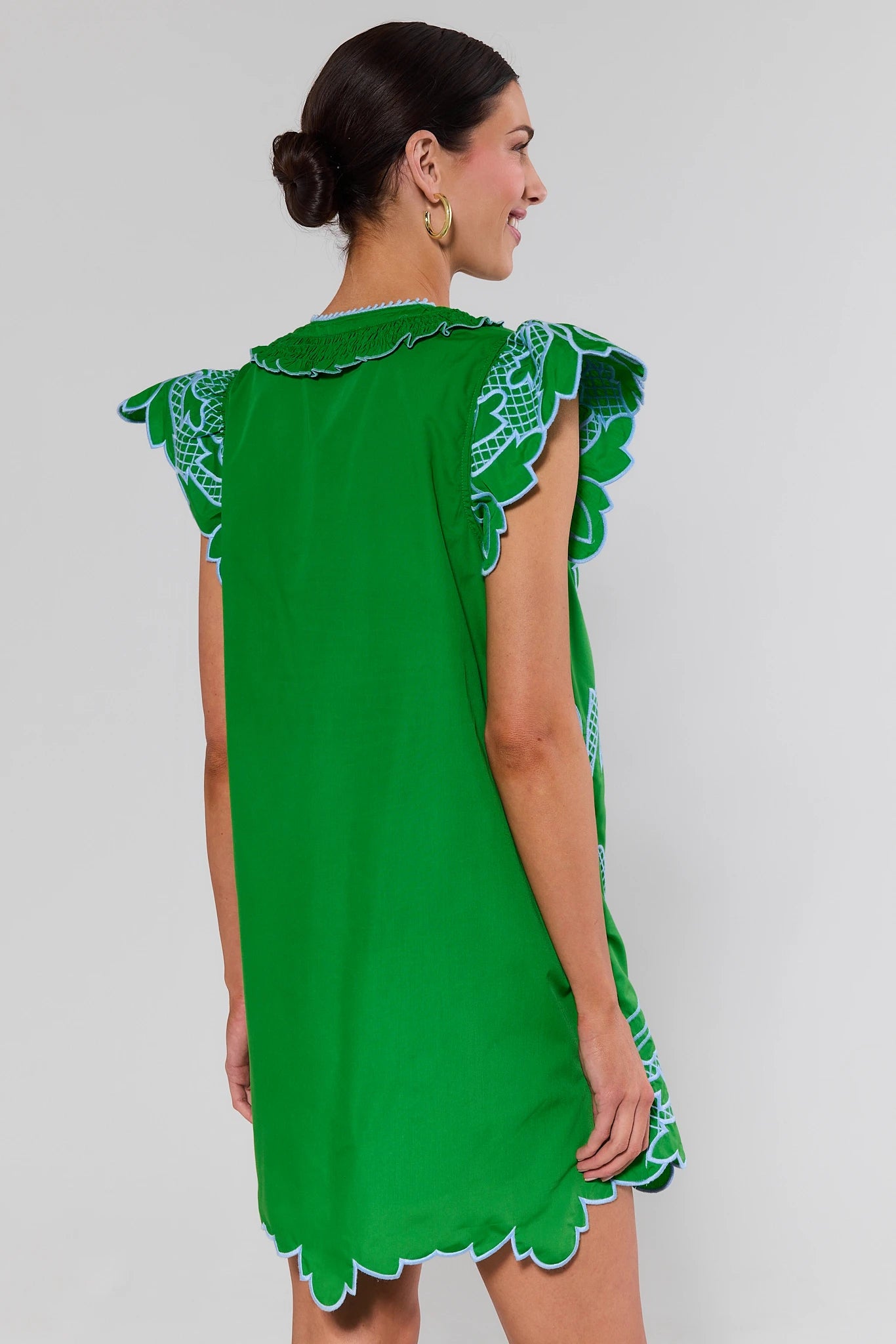 standing Green dress with lace details on a plain background