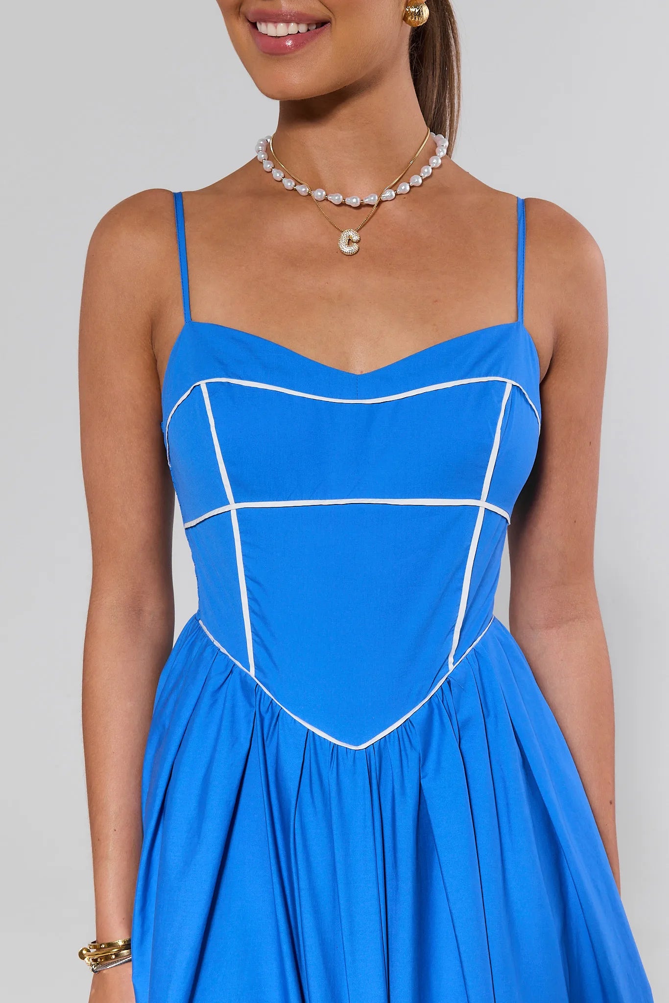 close up Blue dress with white accents worn by a model on a plain background