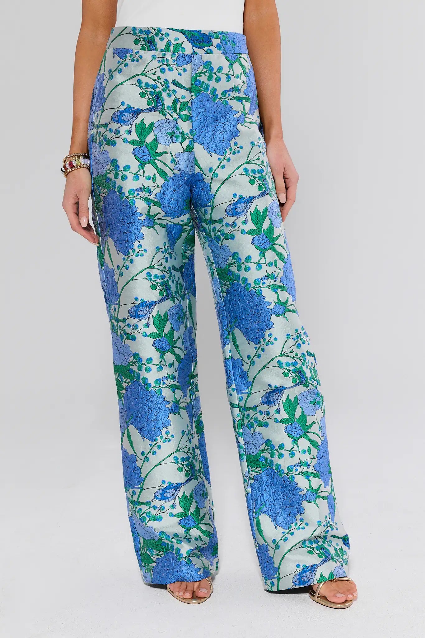 Floral patterned pants worn by a person on a white background