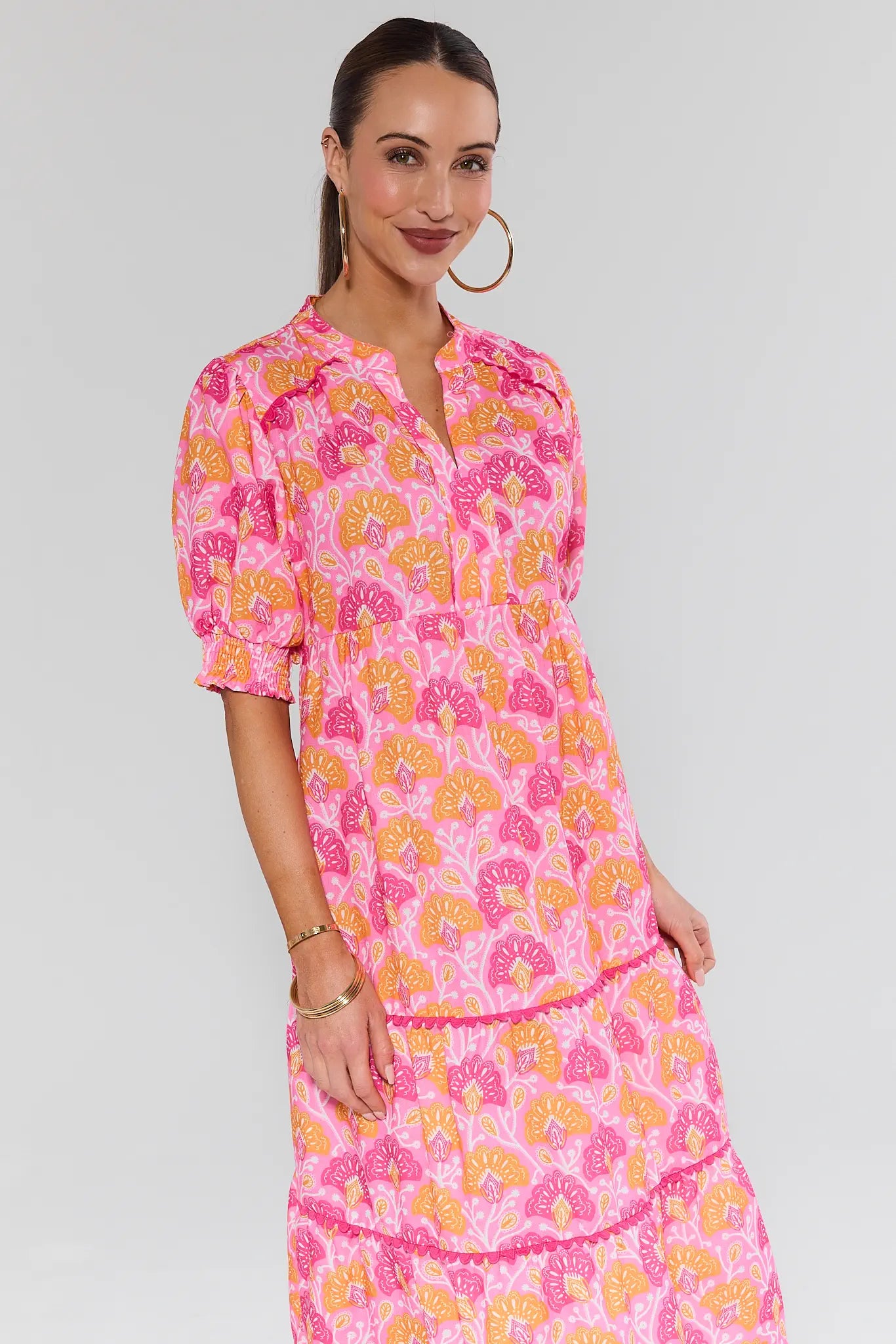 Woman wearing a pink floral dress against a white background