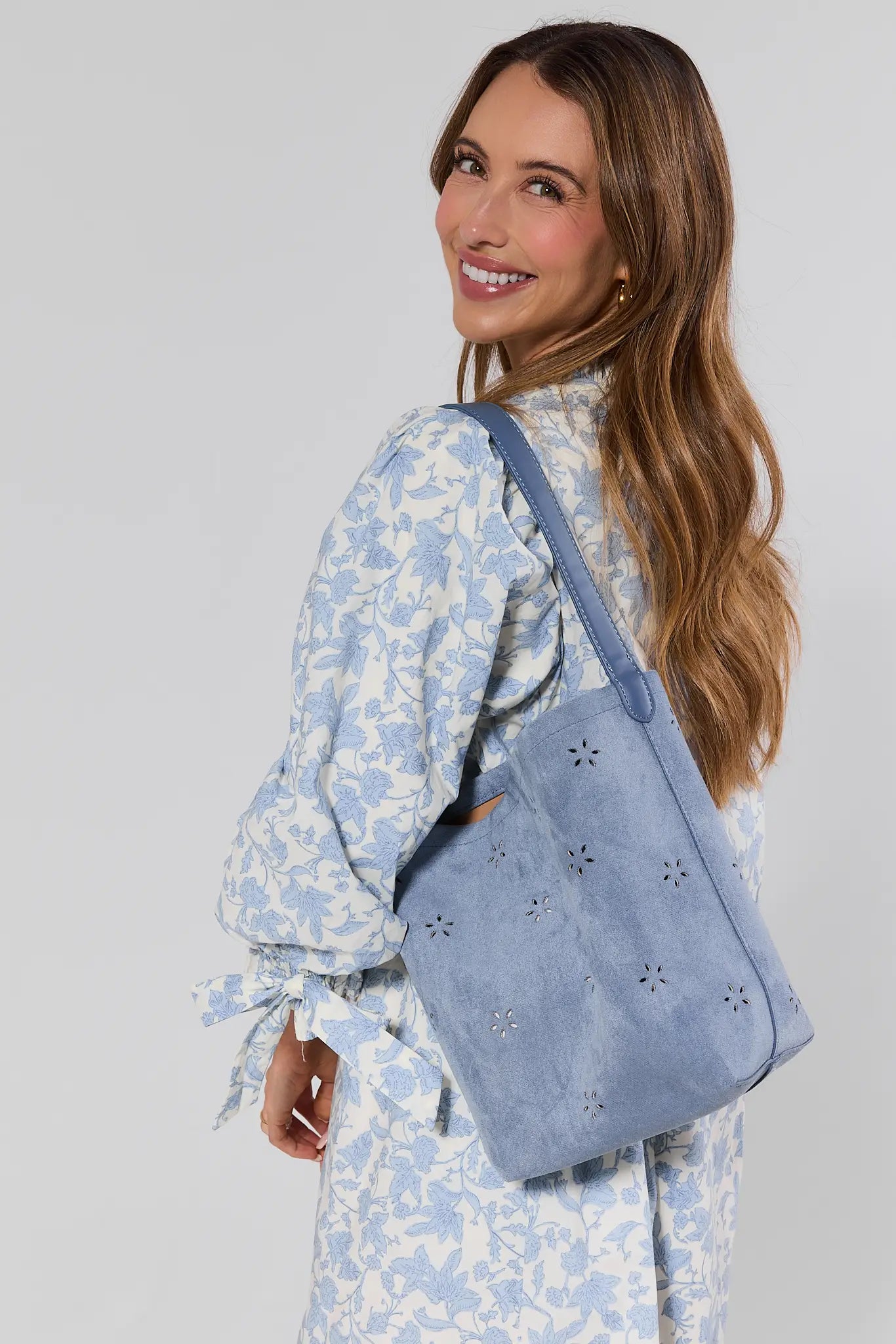 Woman carrying a blue handbag with a white background