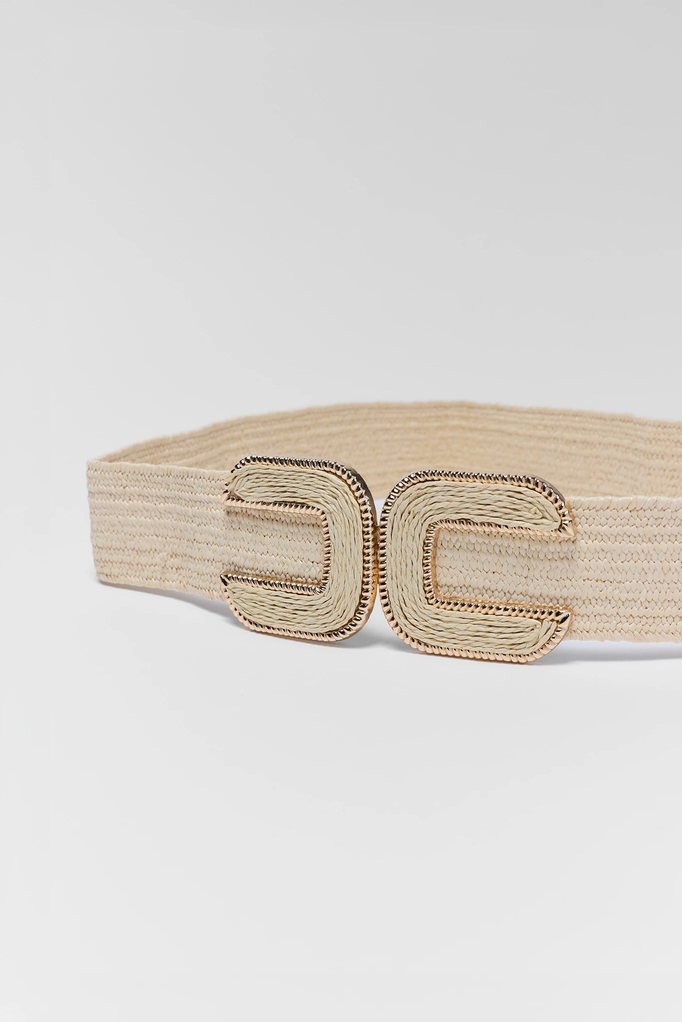 close up Beige headband with a textured pattern on a light gray background