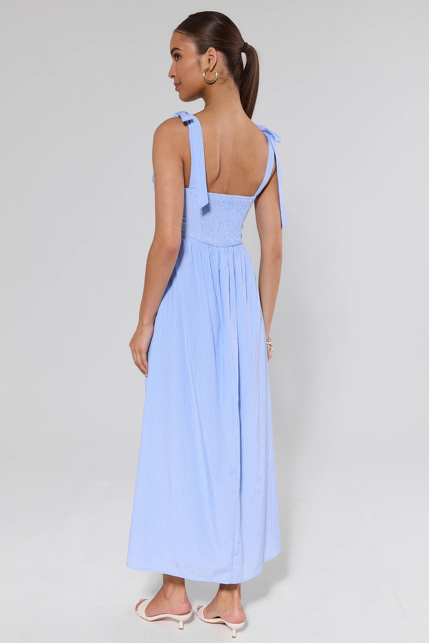 Woman wearing a light blue dress with a plain background