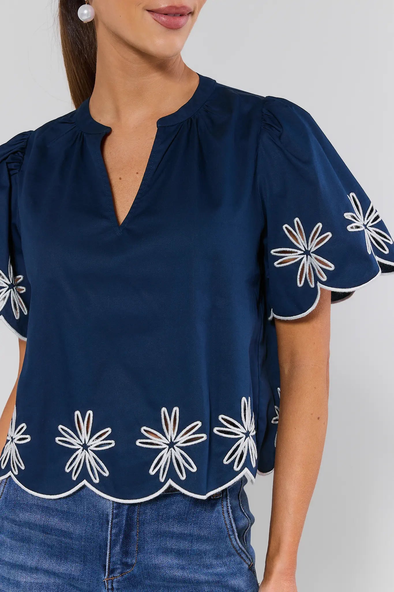 Navy blue blouse with white floral patterns on a plain background