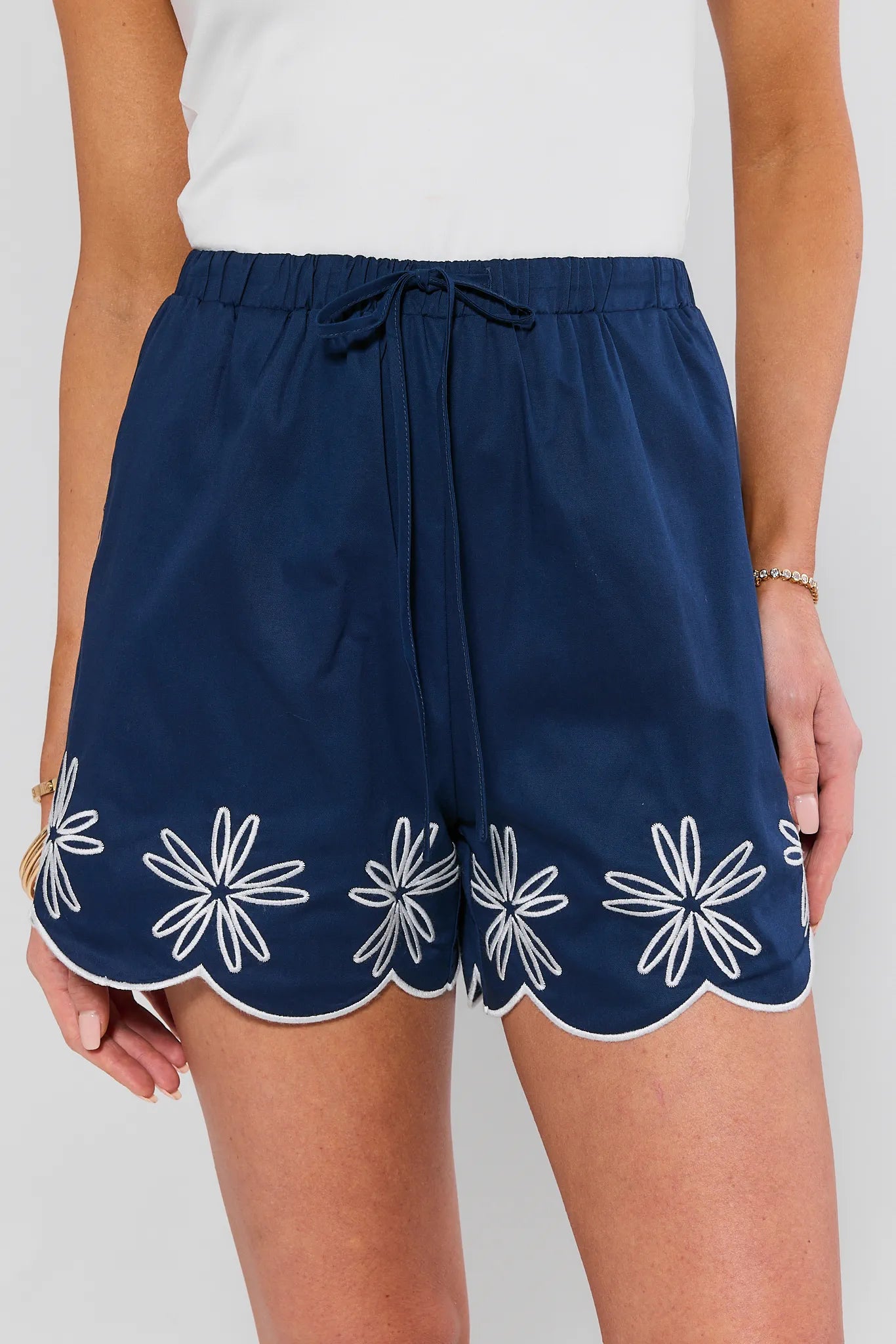 Navy shorts with white floral patterns on a plain background