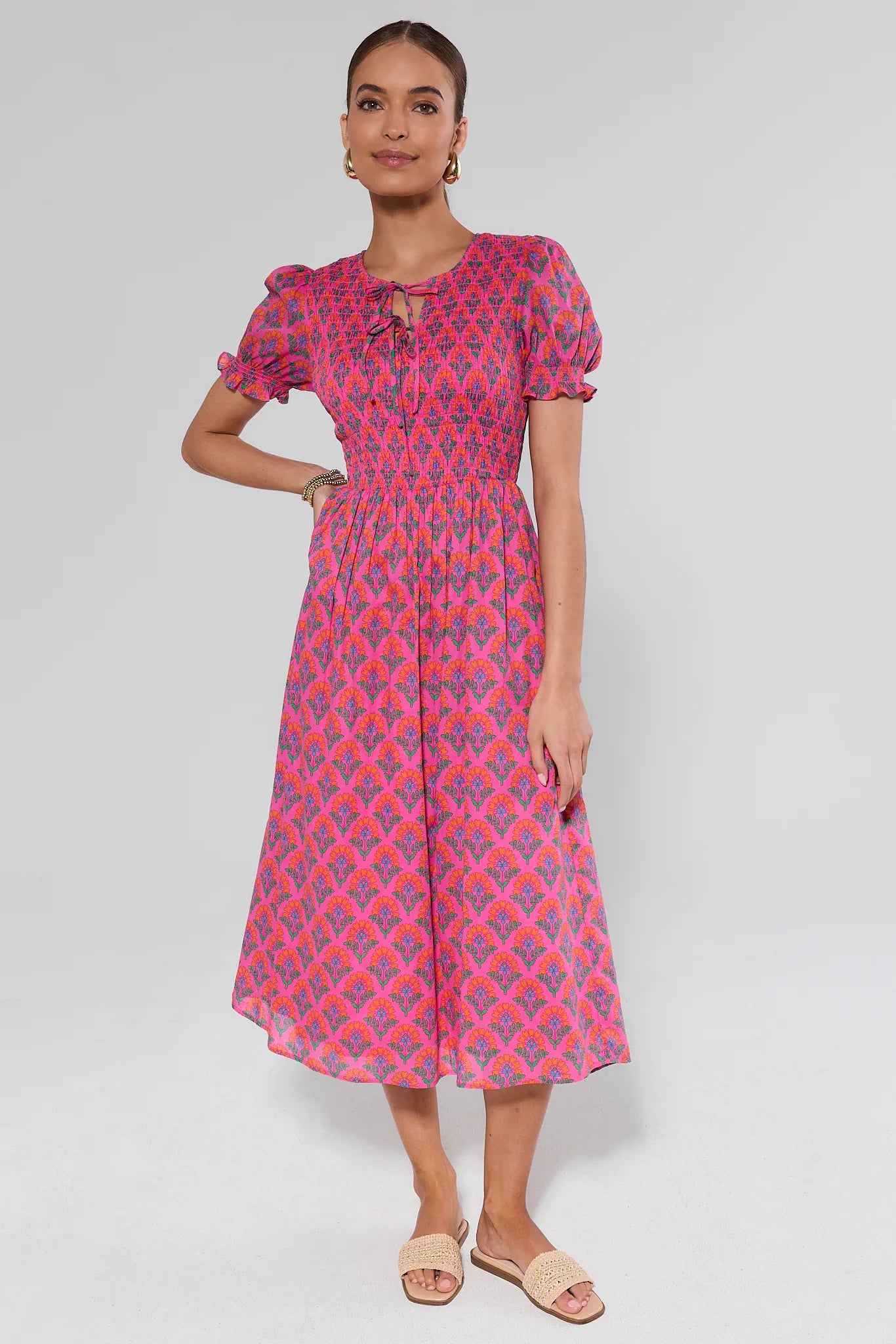 Woman wearing a pink and purple patterned dress on a white background