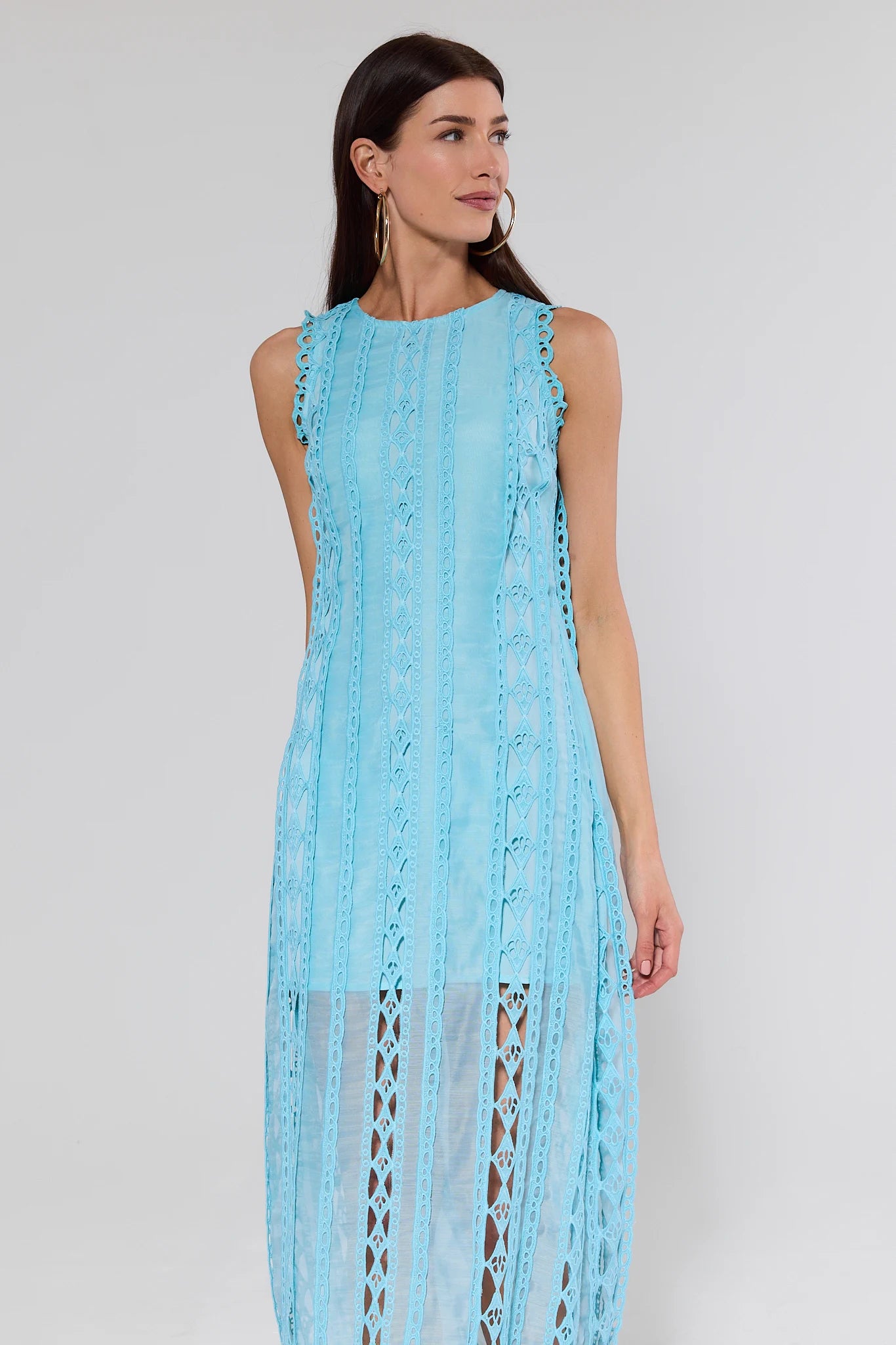 Woman wearing a light blue lace dress against a plain background