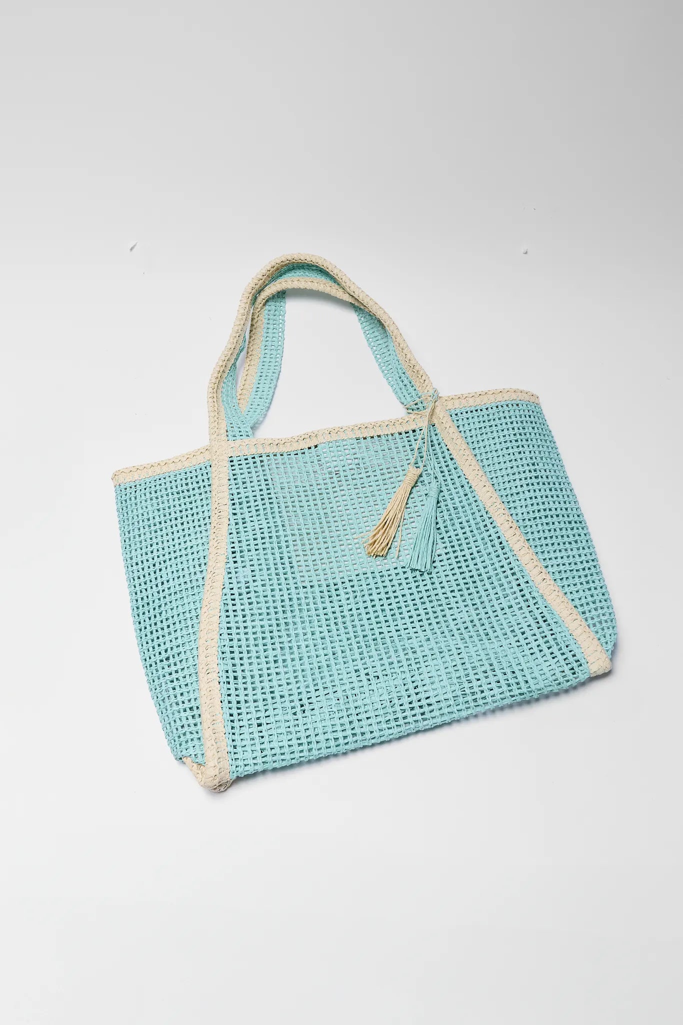 Teal woven bag with beige trim on a white background
