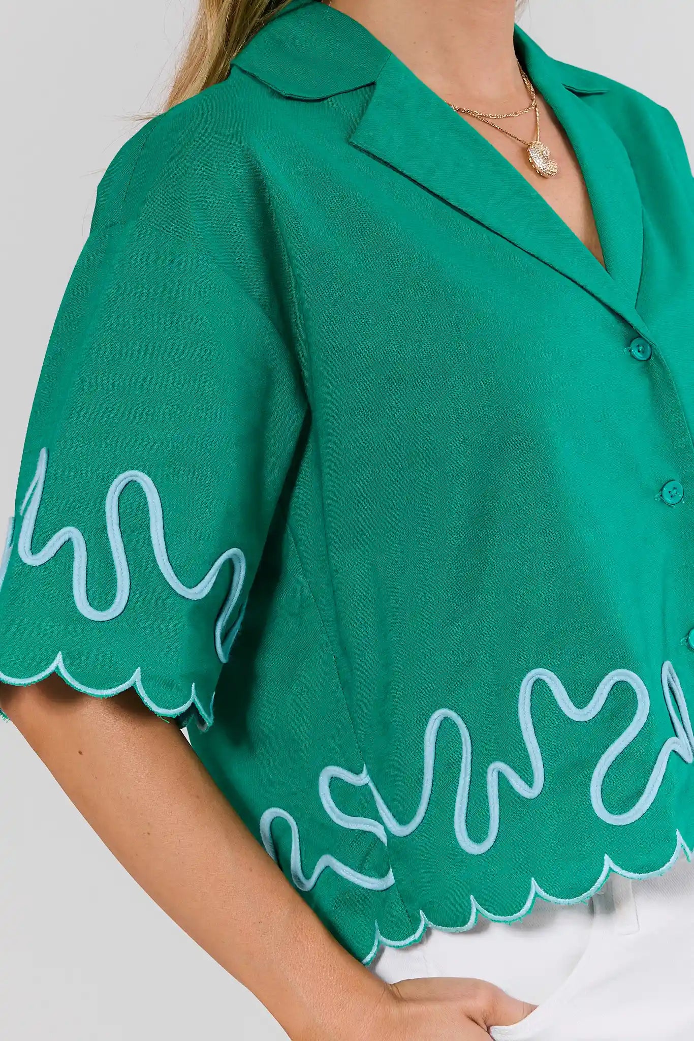 close up Green blouse with white wave patterns on a plain background