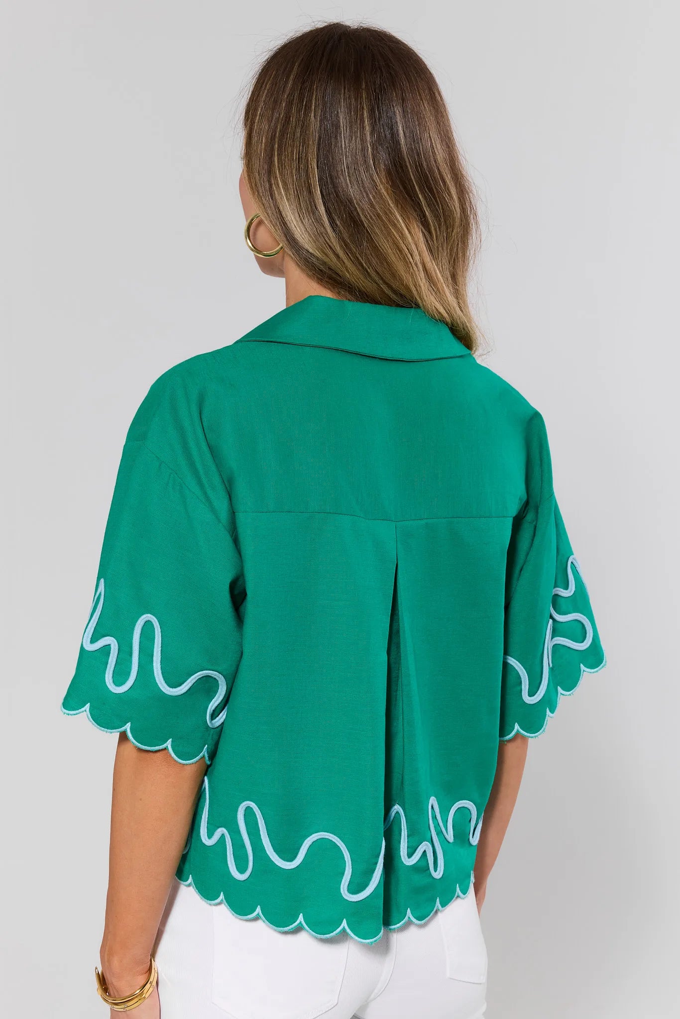 standing Green blouse with white patterns on a plain background
