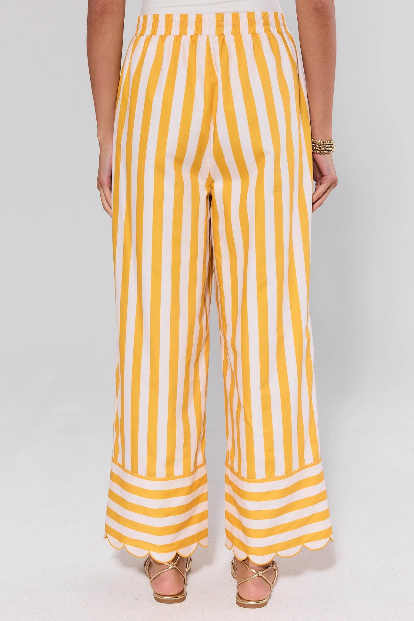 standing Yellow and white striped pants worn by a person on a white background