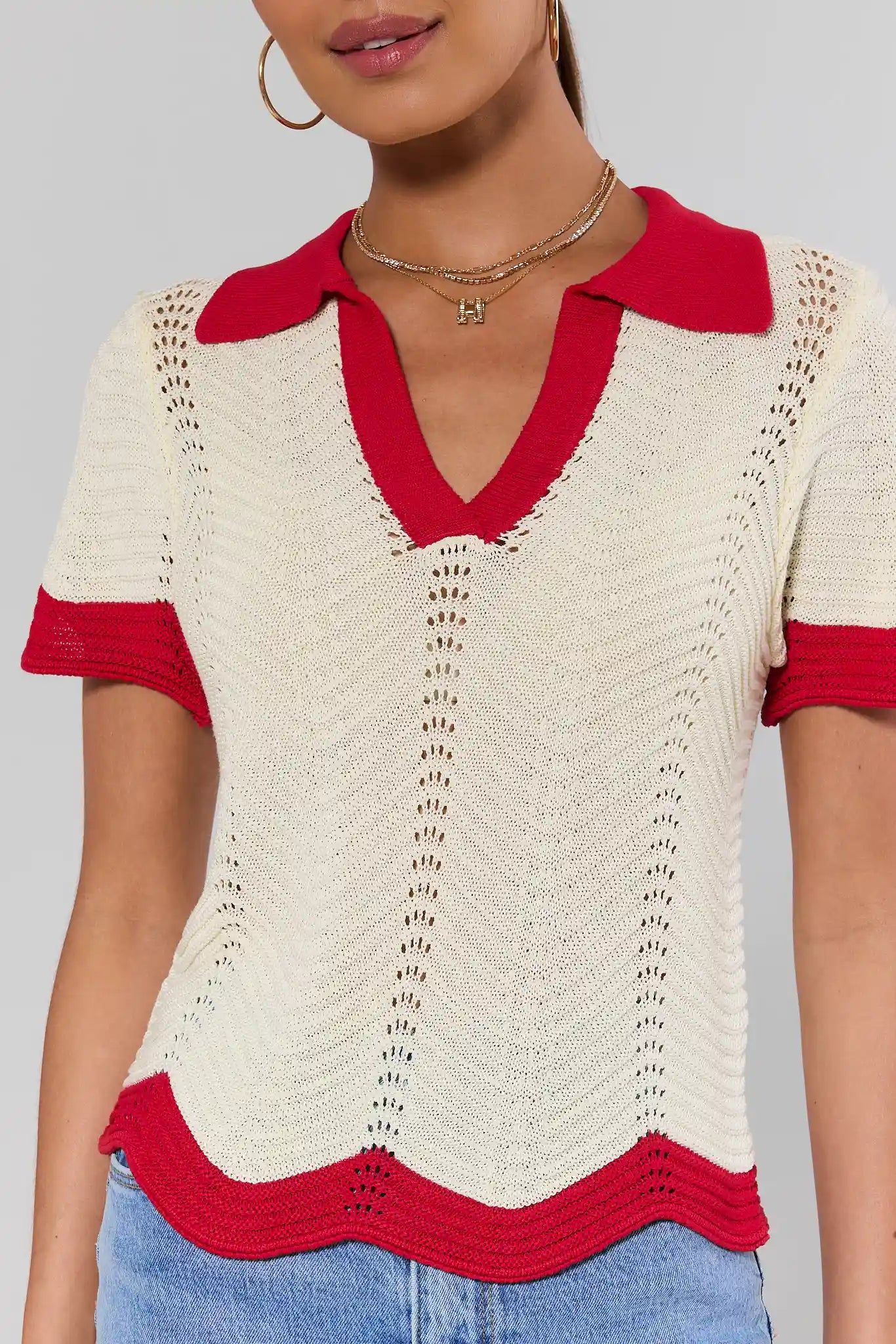 close up Woman wearing a red and white patterned top with a plain background