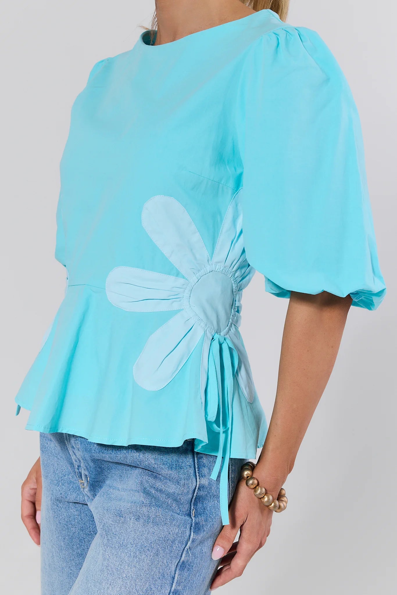 Light blue blouse with a floral design on a plain background