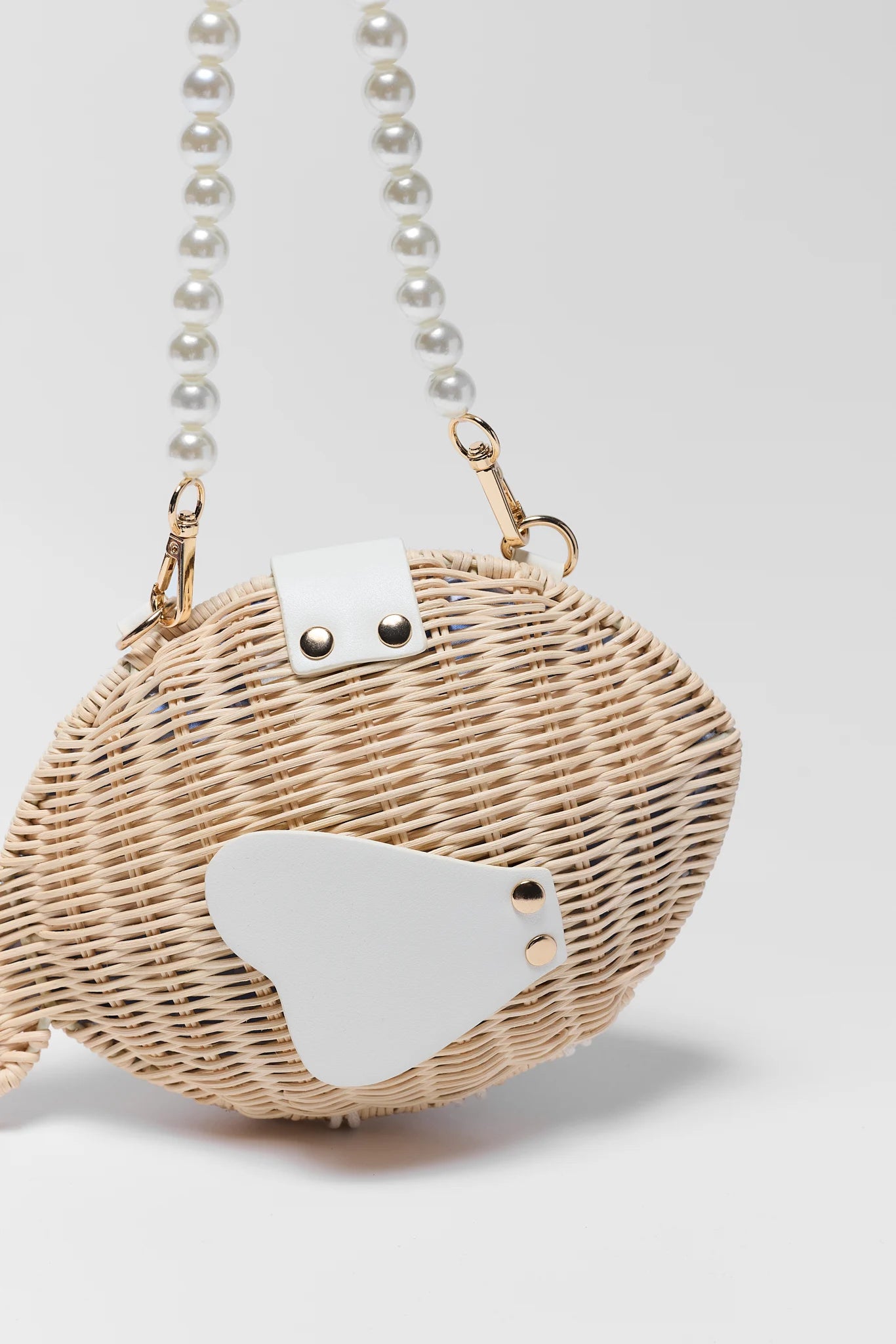 close up Wicker handbag with a white patch on a light gray background
