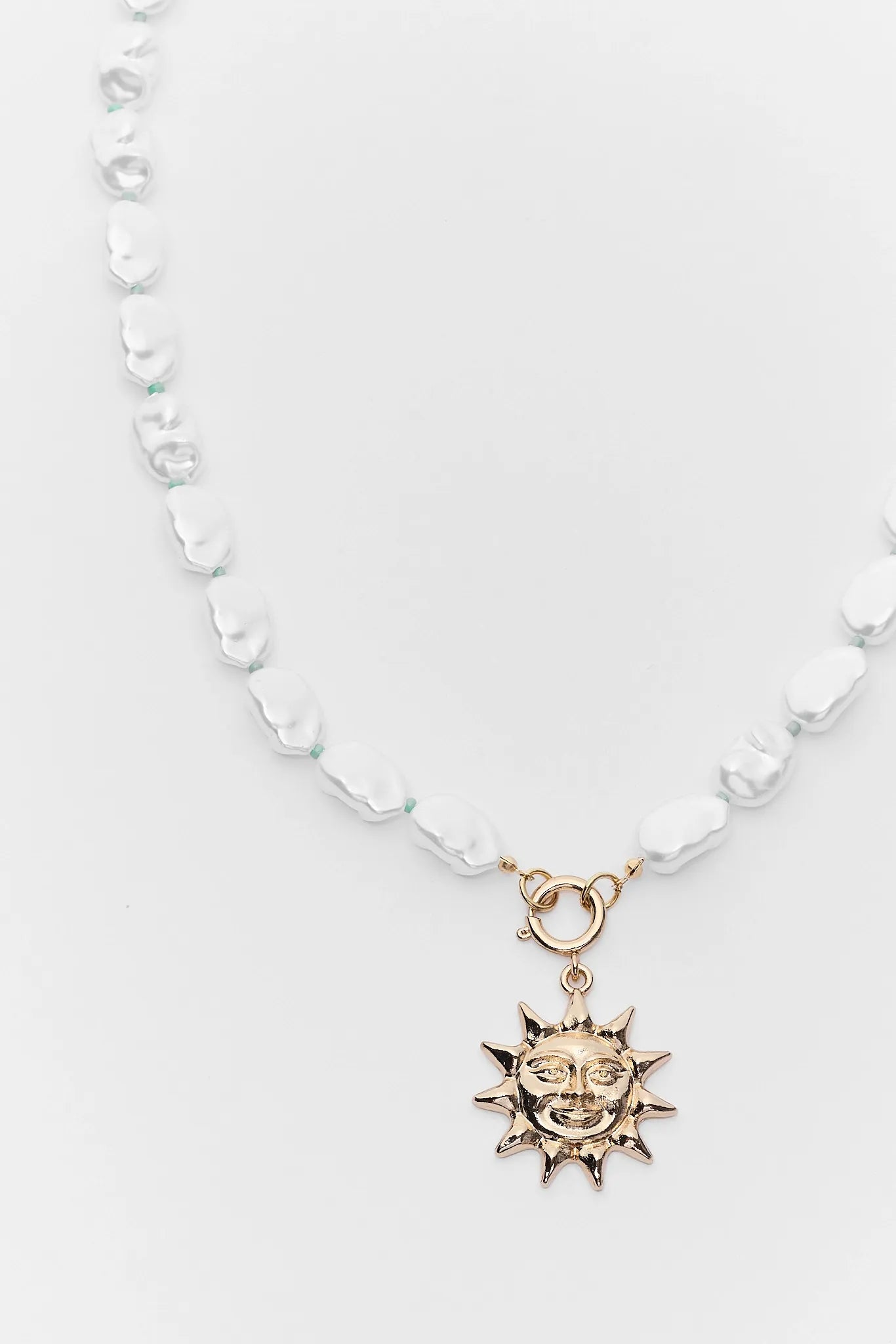 Necklace with a sun pendant on a white background close up 