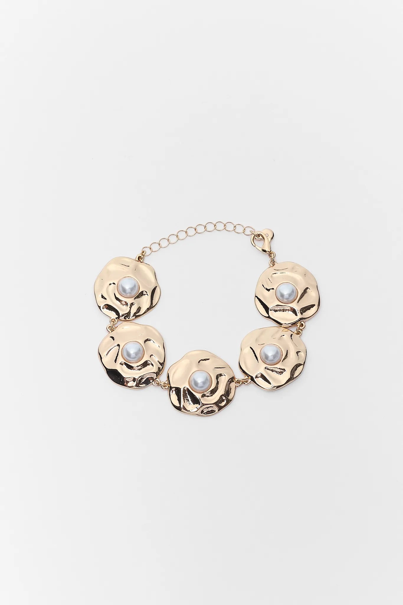 Gold necklace with pearl-like beads on a light gray background