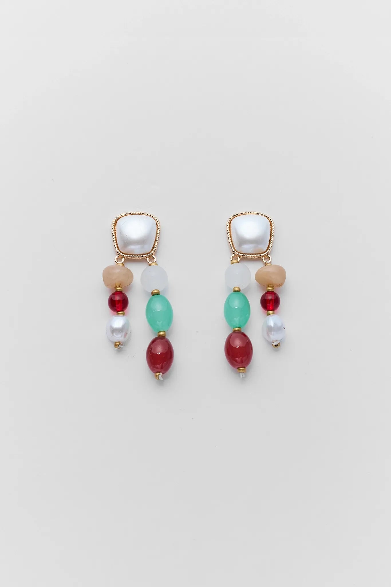 Pair of earrings with colorful beads on a light gray background