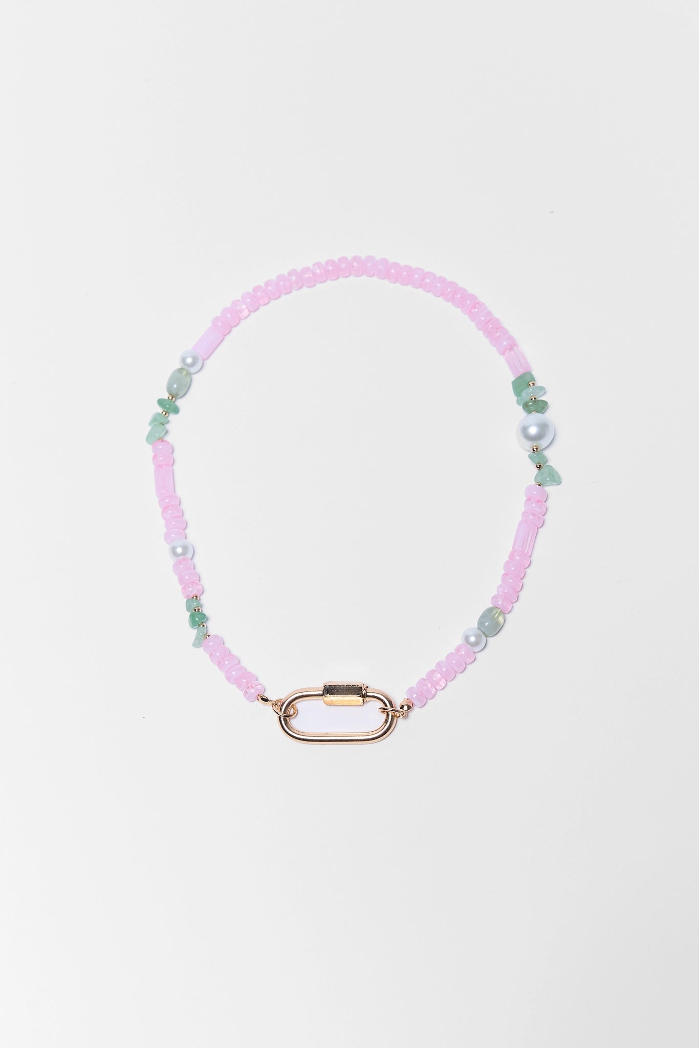 Necklace with pink and green beads on a light gray background