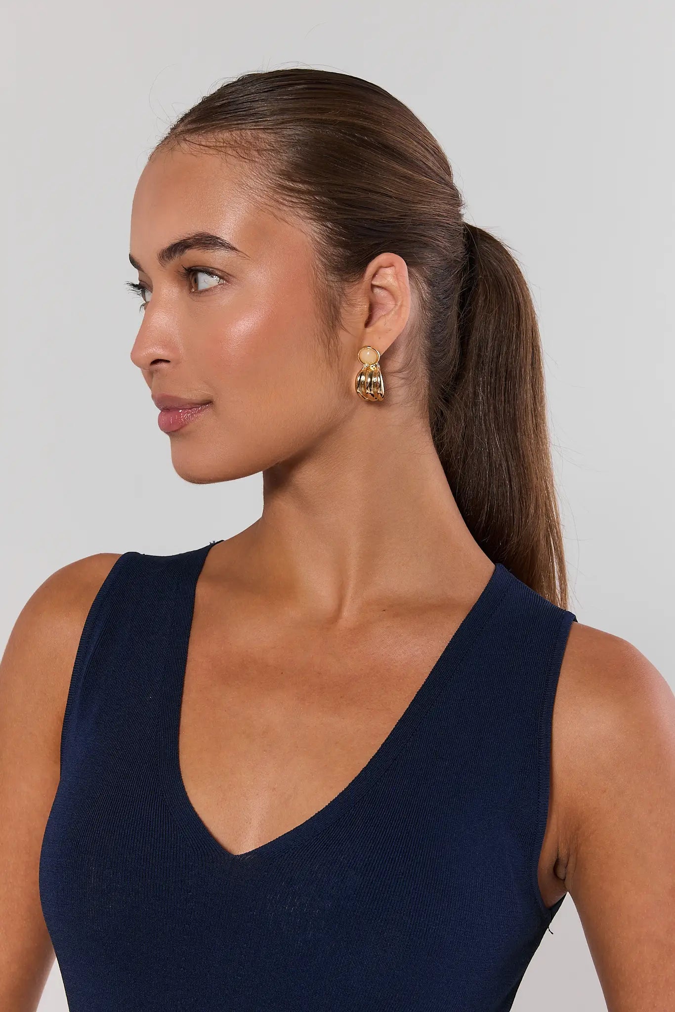 woman wearing gold fluted stud earrings