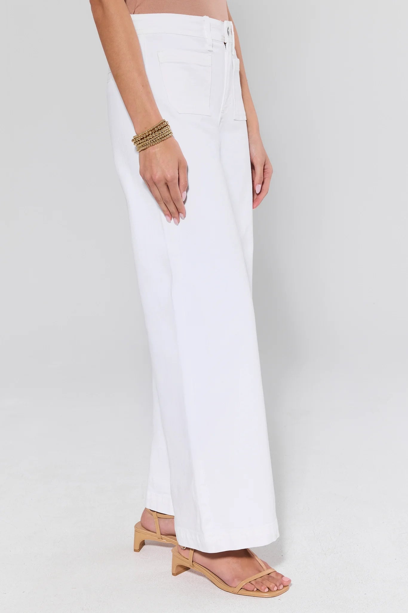 White pants worn by a person on a white background