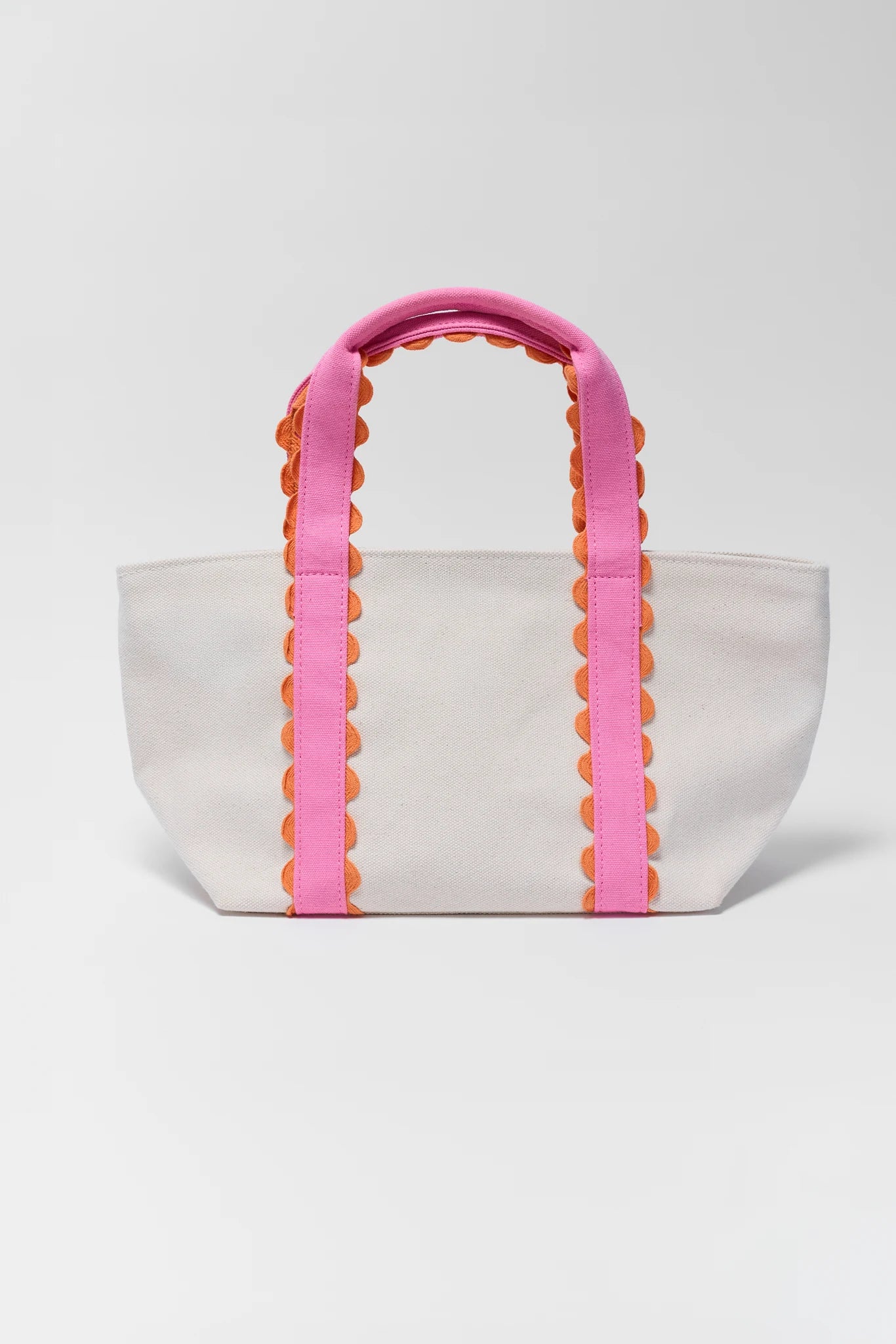 White tote bag with pink and orange handles on a white background