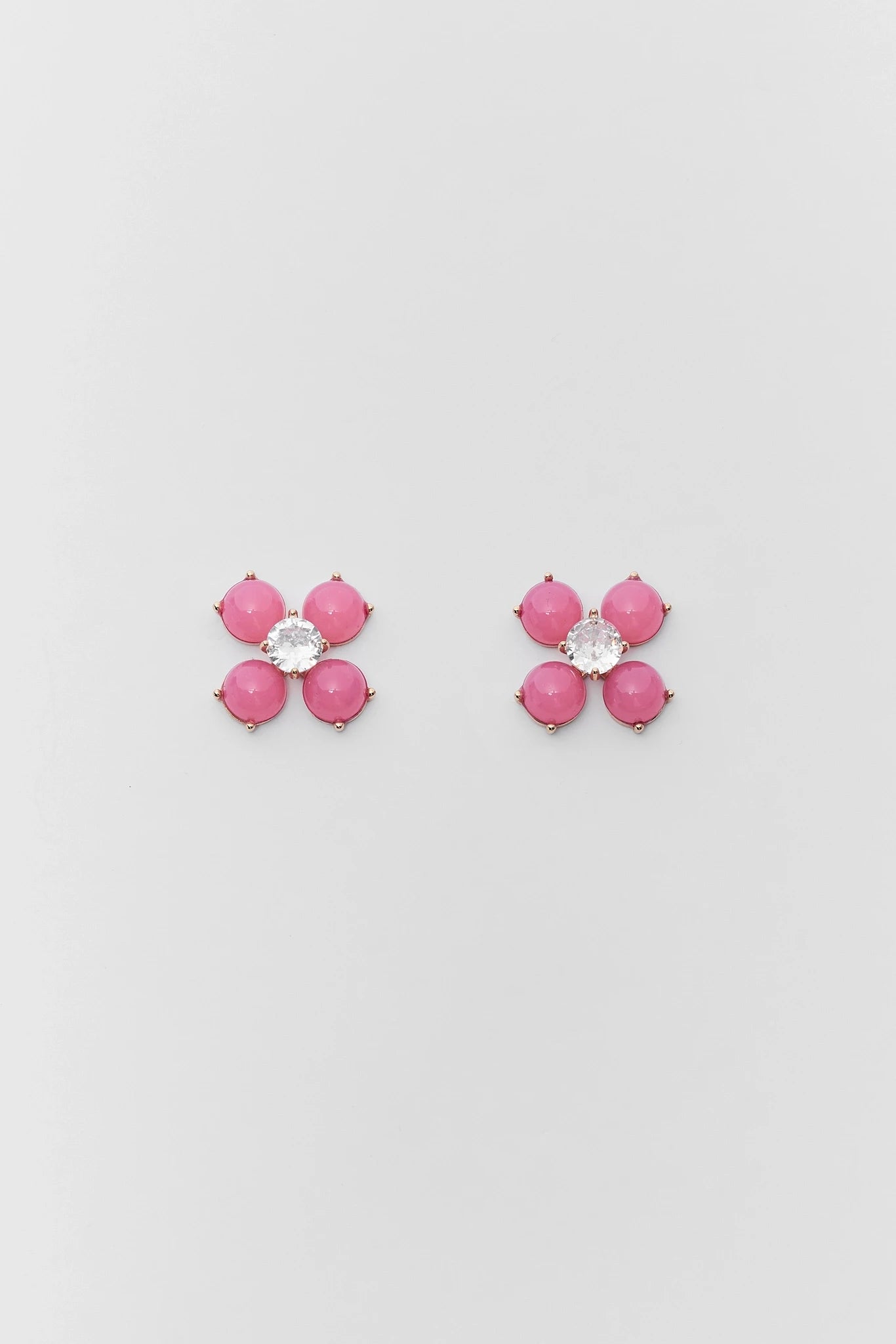 Pair of pink flower-shaped earrings on a light gray background