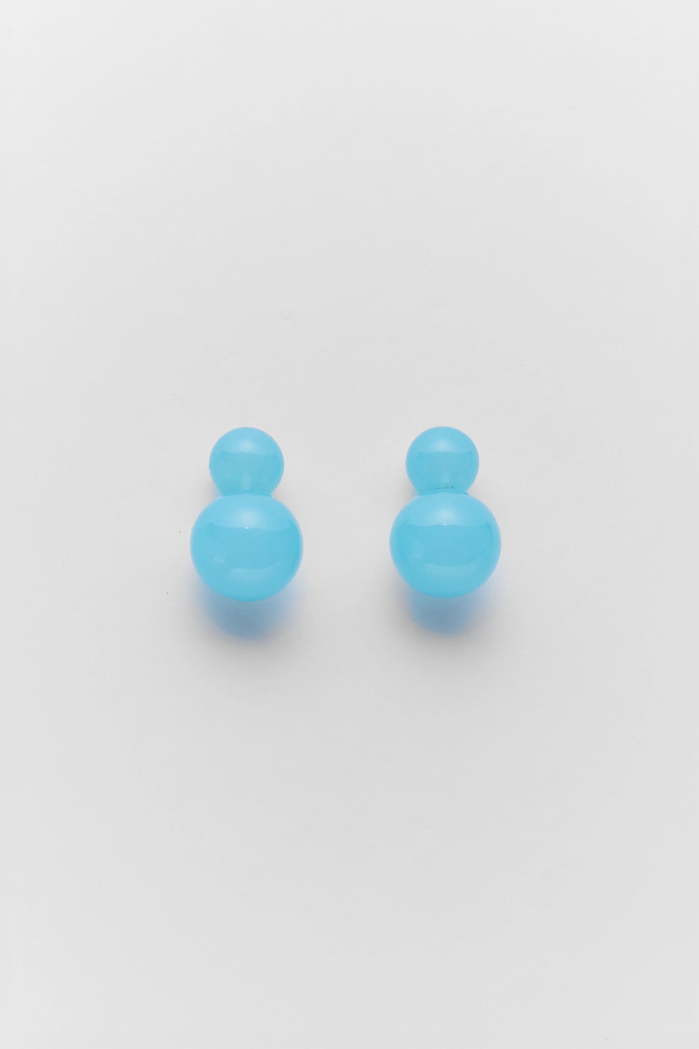 Pair of blue earrings on a light gray background