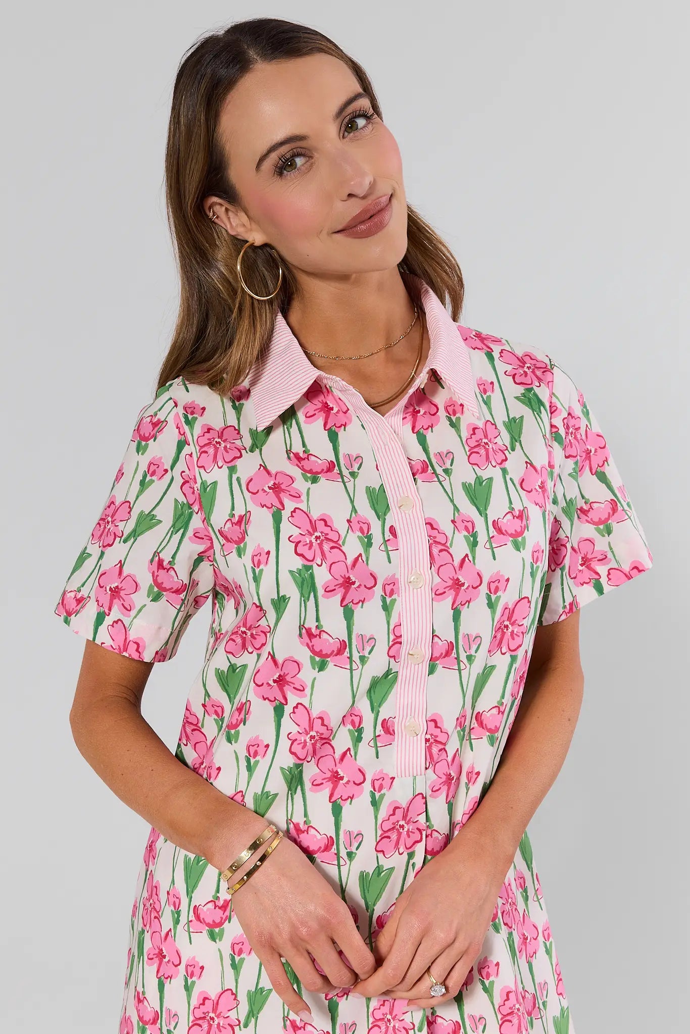 close up Woman wearing a floral dress with pink flowers on a plain background