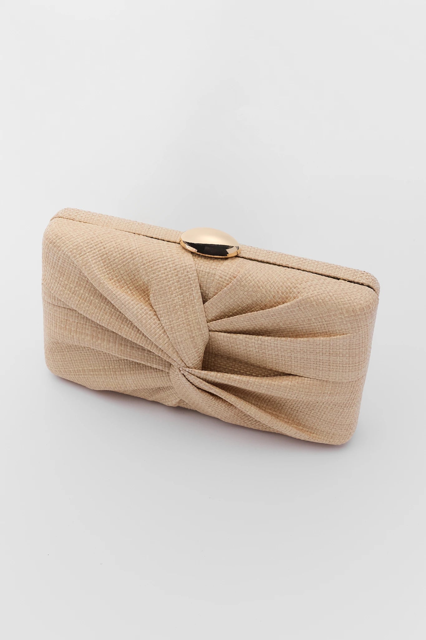 close up Beige clutch bag with a knot detail on a light gray background