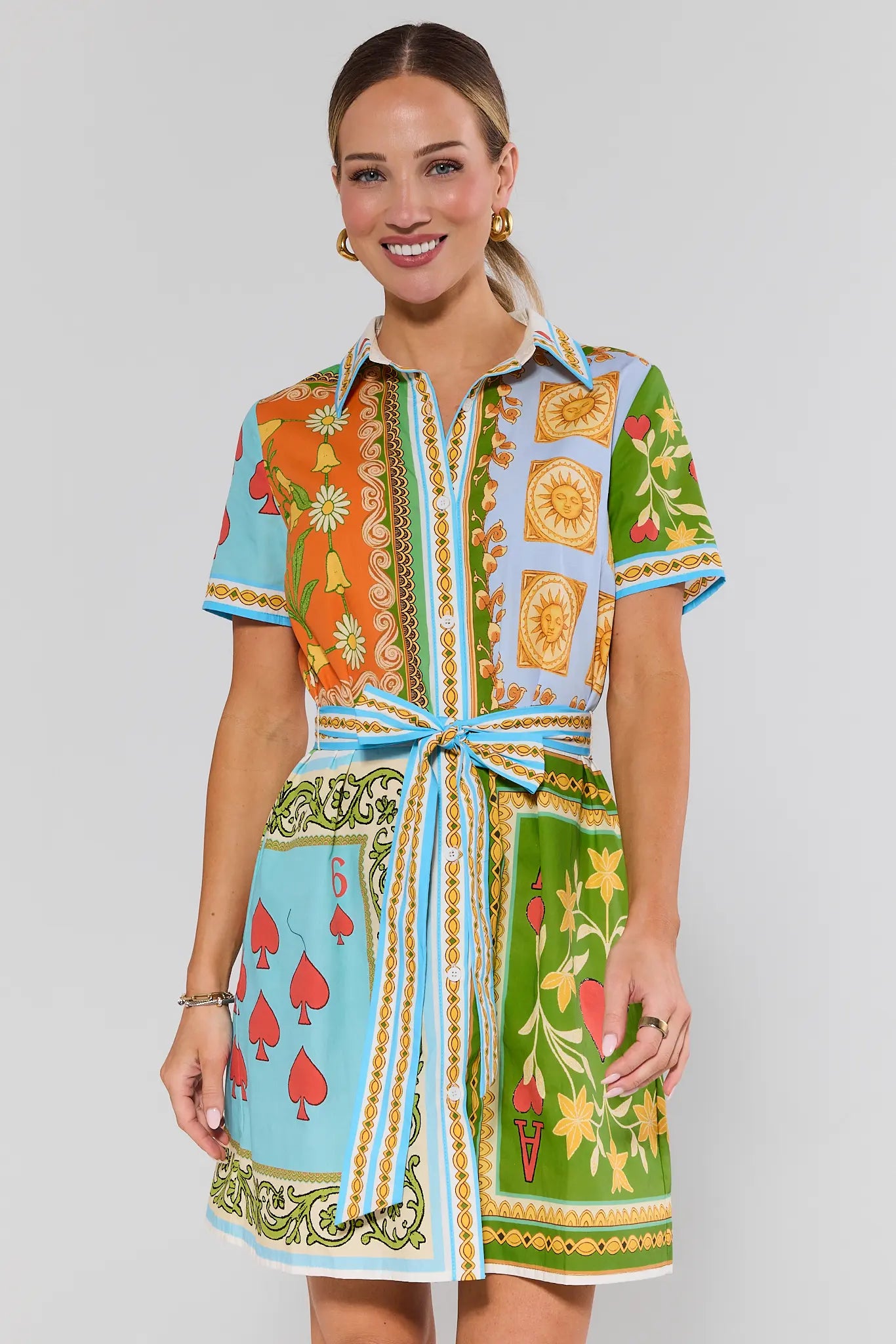 Woman wearing a colorful alys patterned dress on a plain background