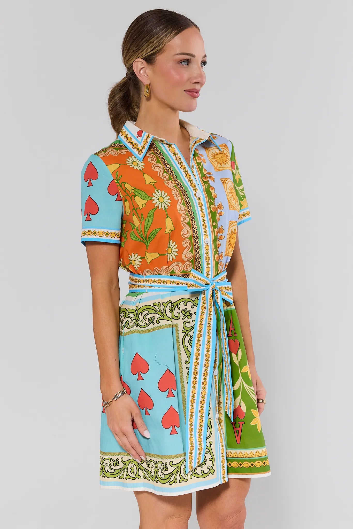 side shot Woman wearing a colorful patterned dress on a plain background