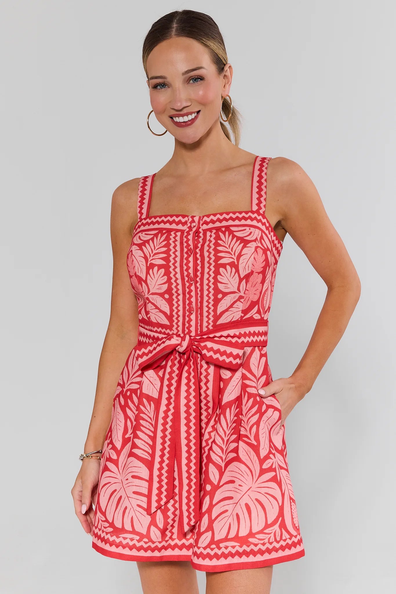 Woman wearing a red and white patterned dress against a plain background