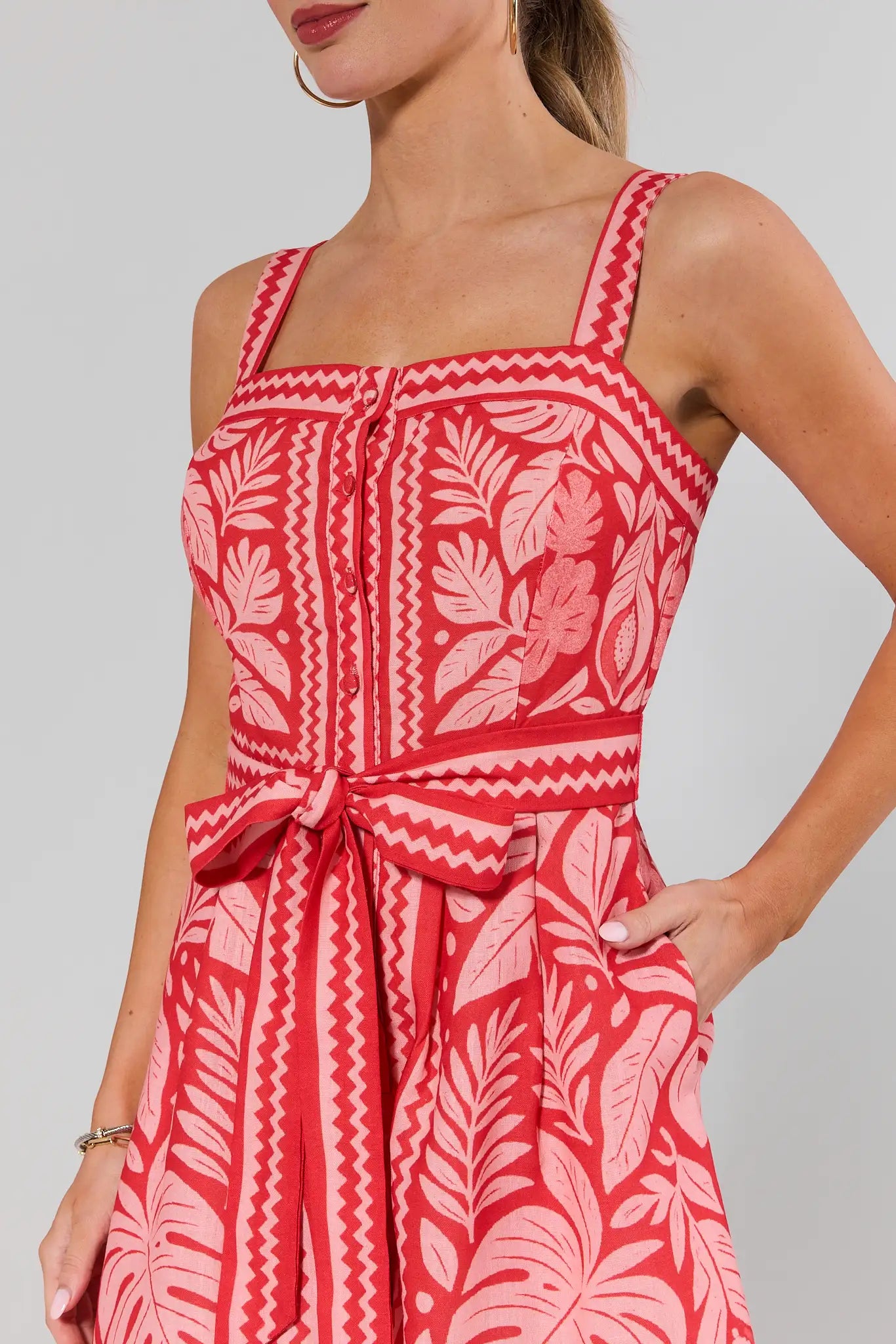 close up Woman wearing a red and white patterned dress against a gray background