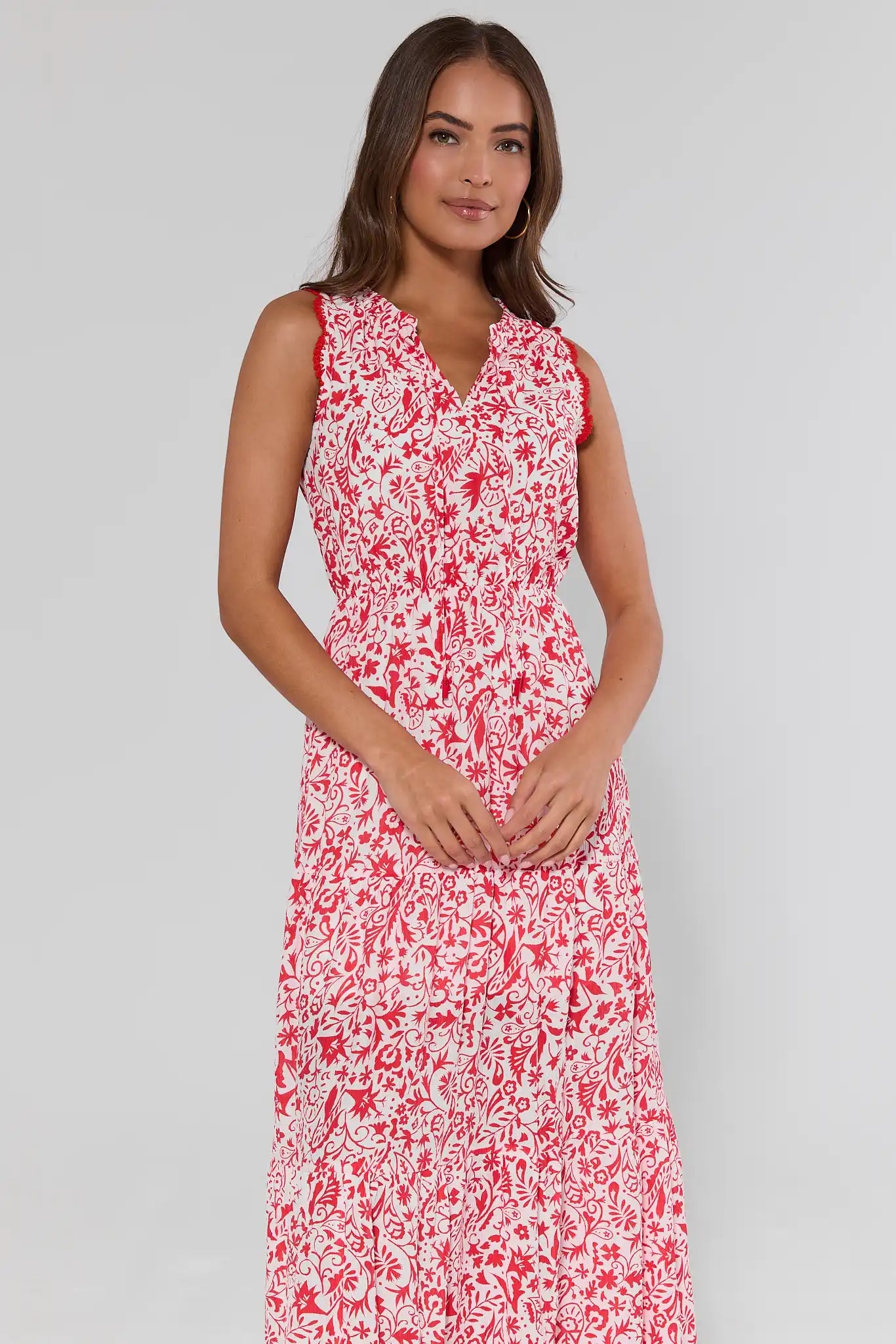 Woman wearing a red and white floral dress on a gray background
