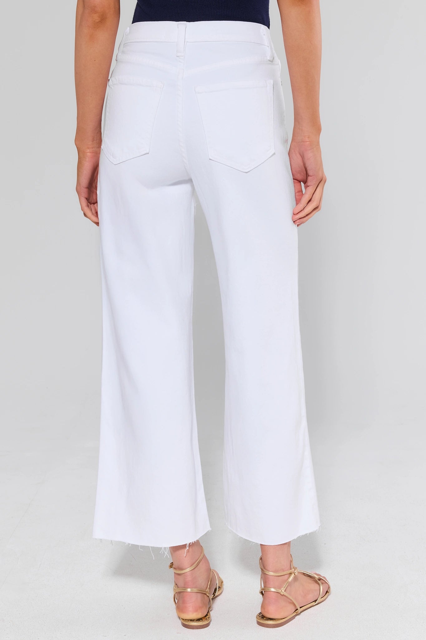 White wide-leg pants standing worn by a person on a plain background