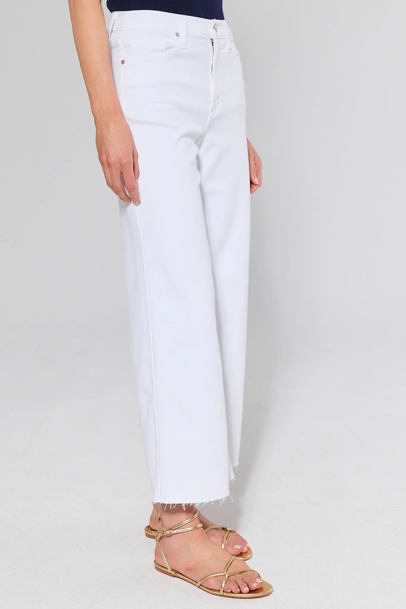 side shot White jeans worn by a person on a plain background