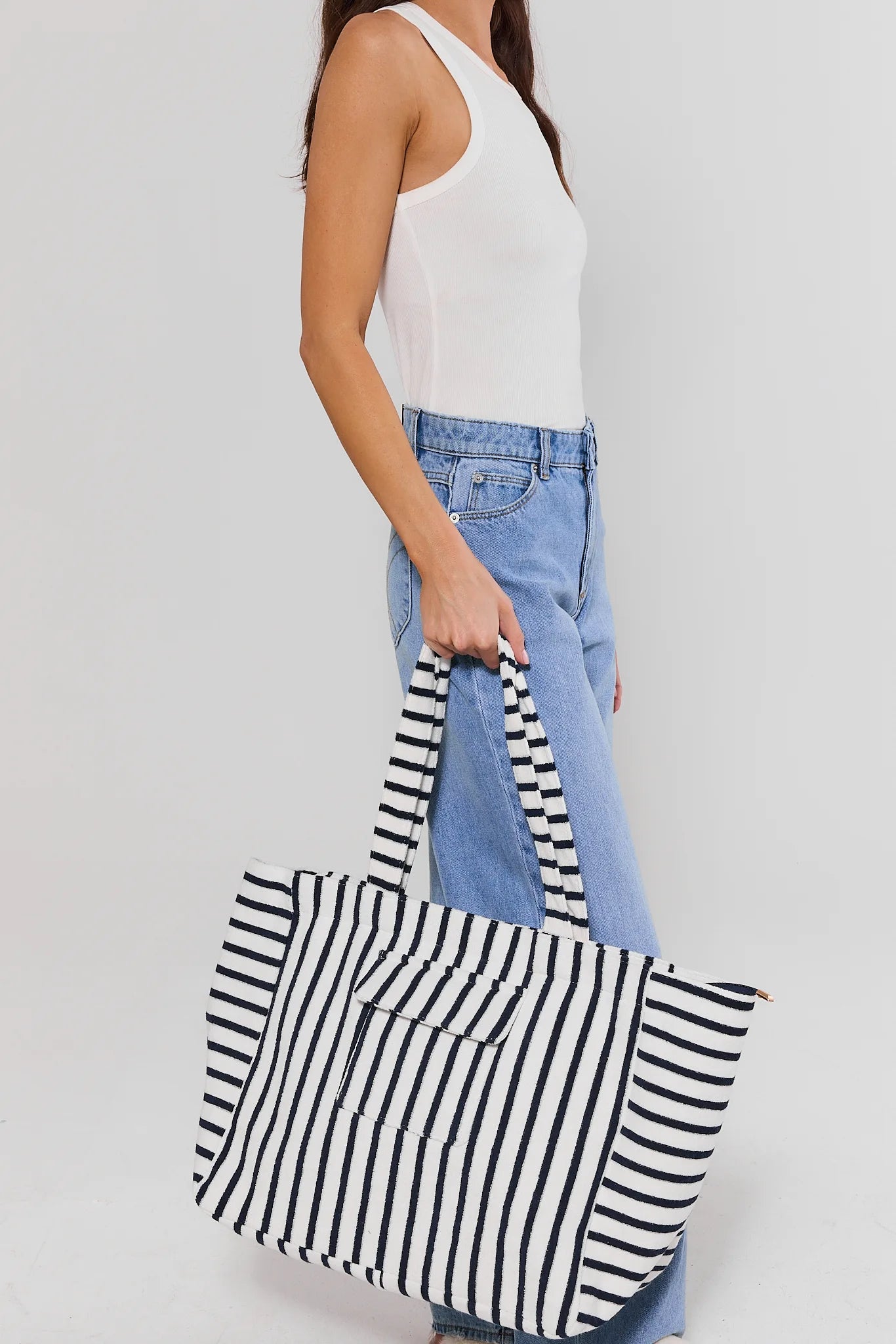 Person holding a black and white striped bag with a plain background