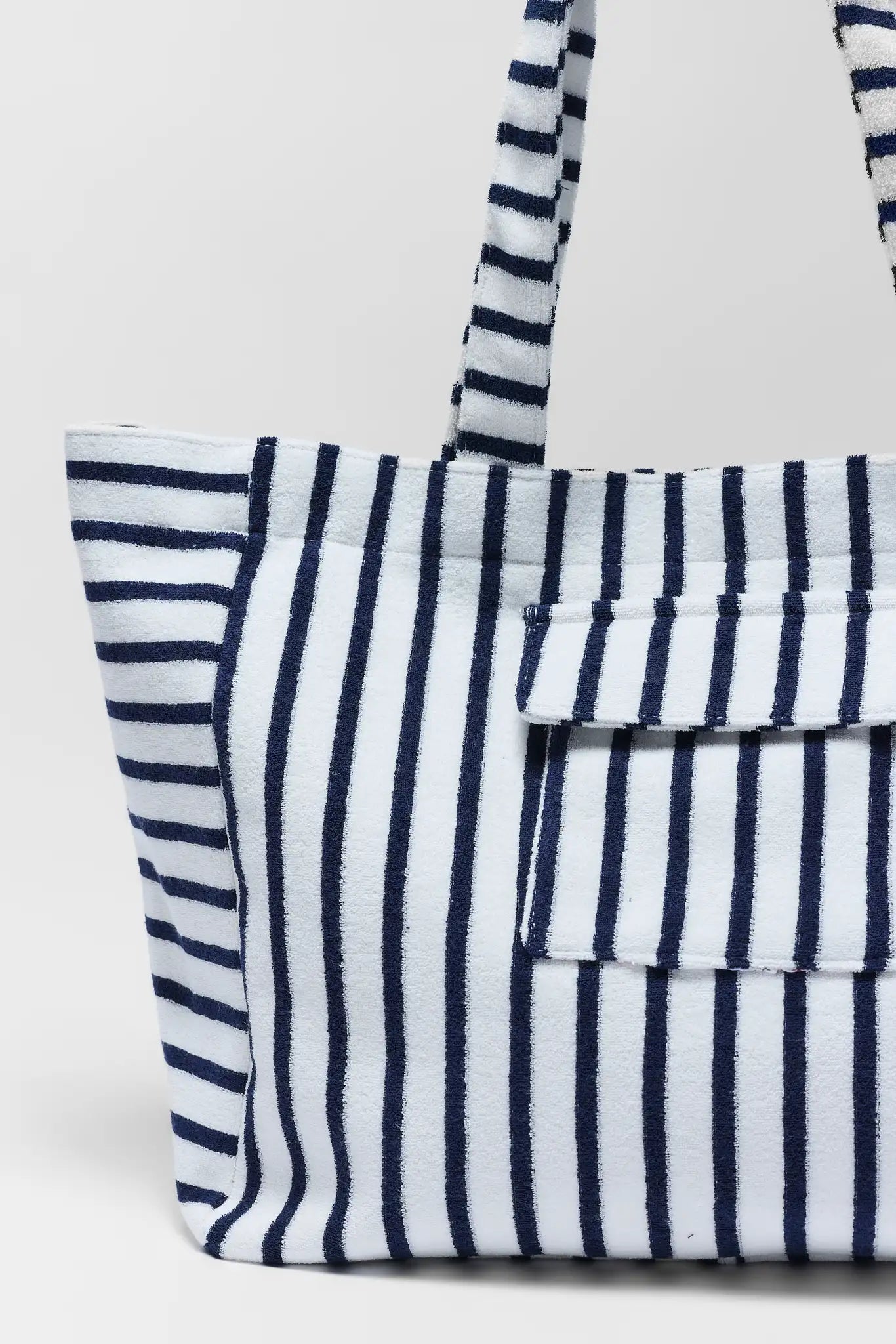 close up Navy and white striped tote bag on a light gray background