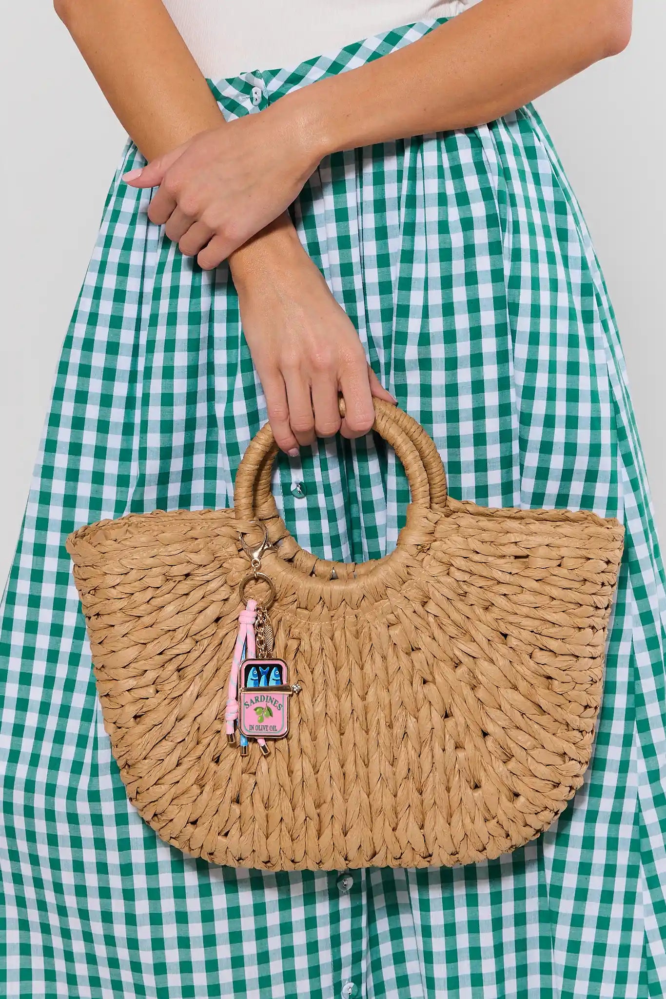 Keychain with colorful tassels and a small pouch charm on a bag on a light gray background