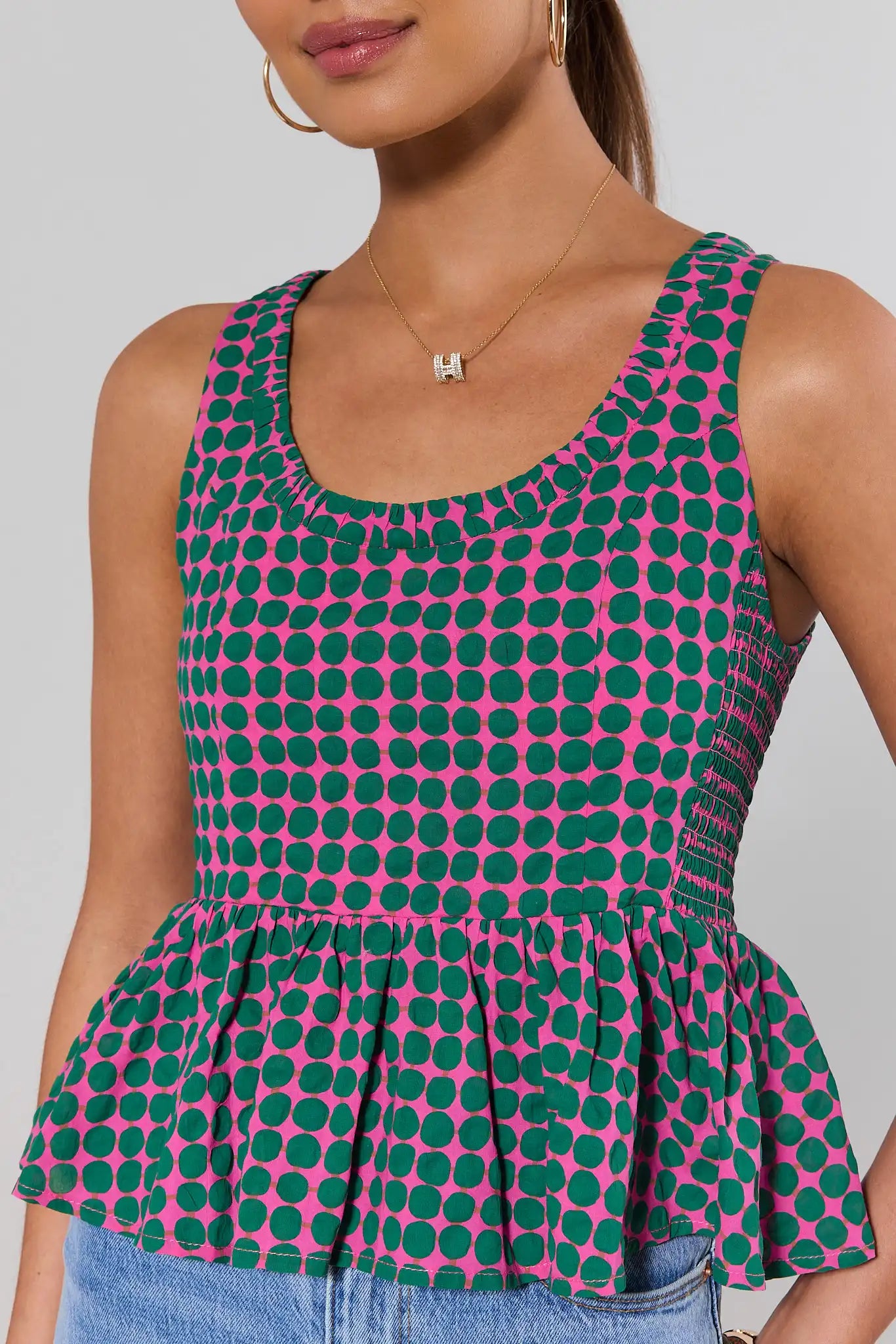 close up Woman wearing a polka dot top with a plain background