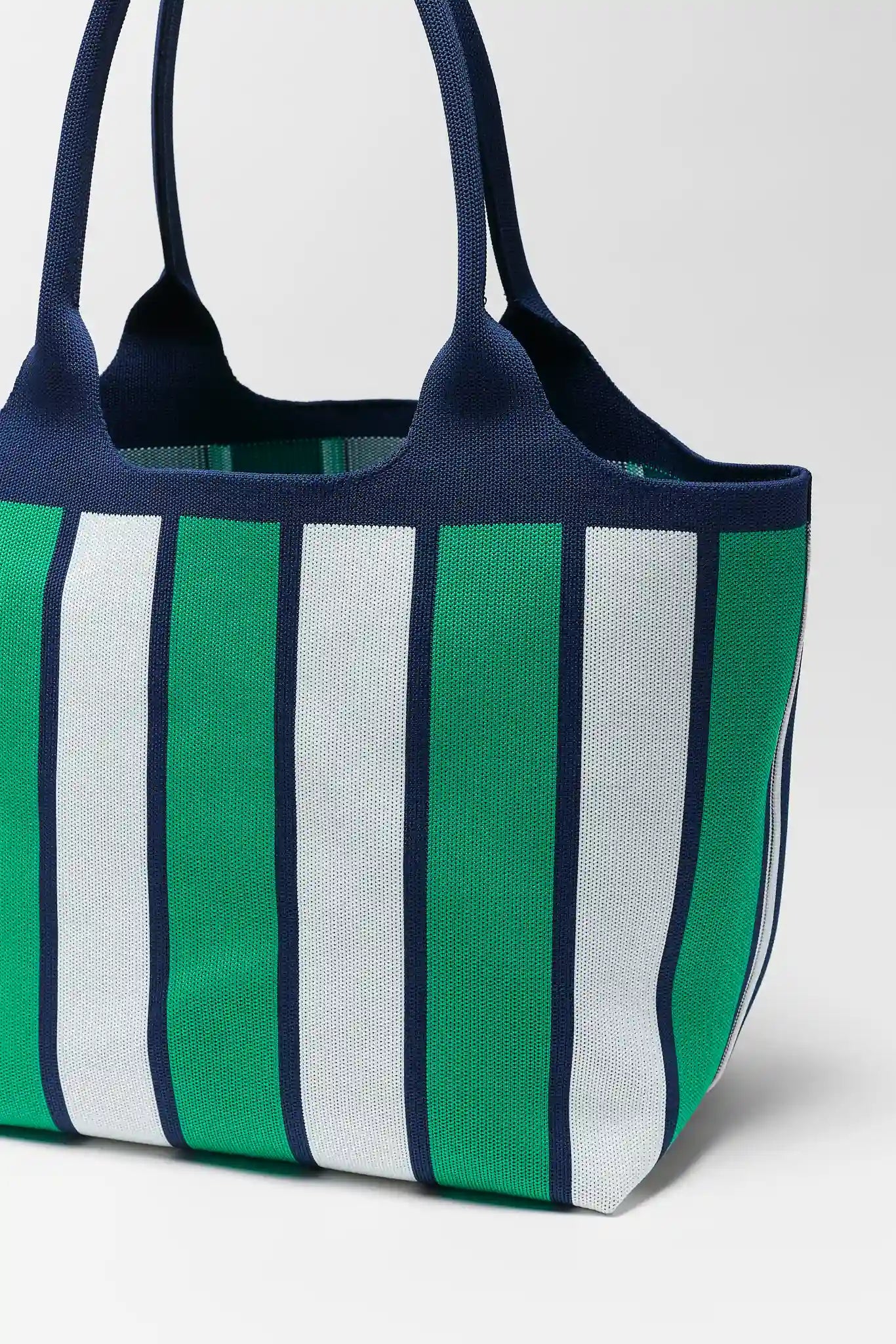 close up Striped tote bag with green, white, and navy pattern on a light gray background