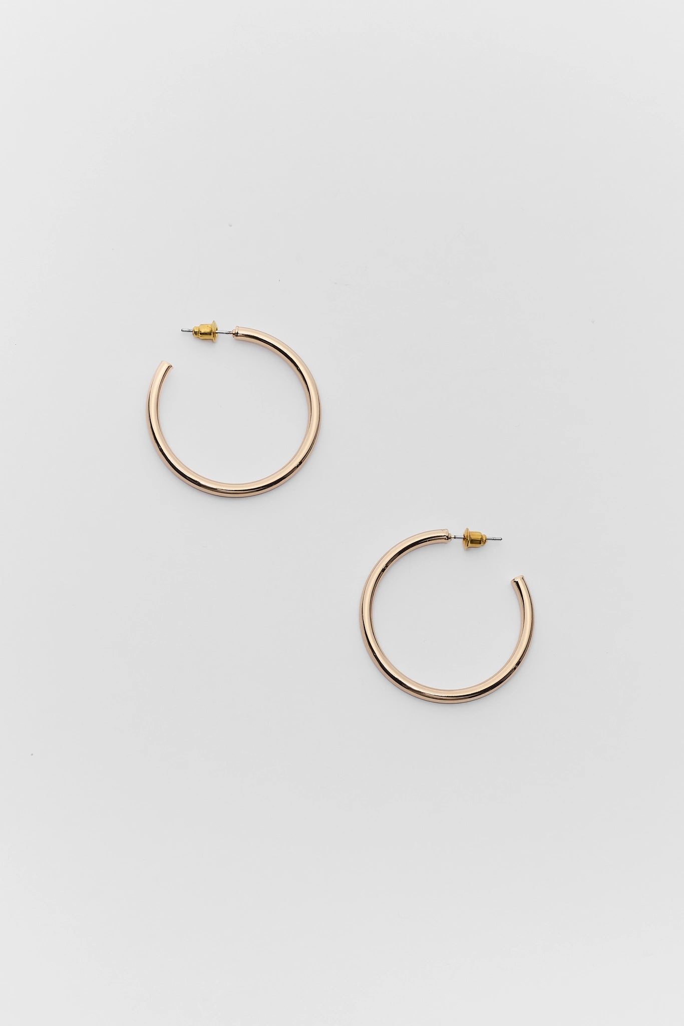 Gold hoop earrings on a light gray background