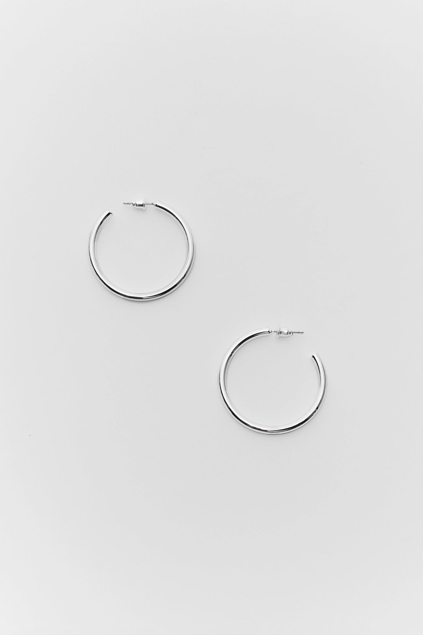 Pair of silver hoop earrings on a light gray background